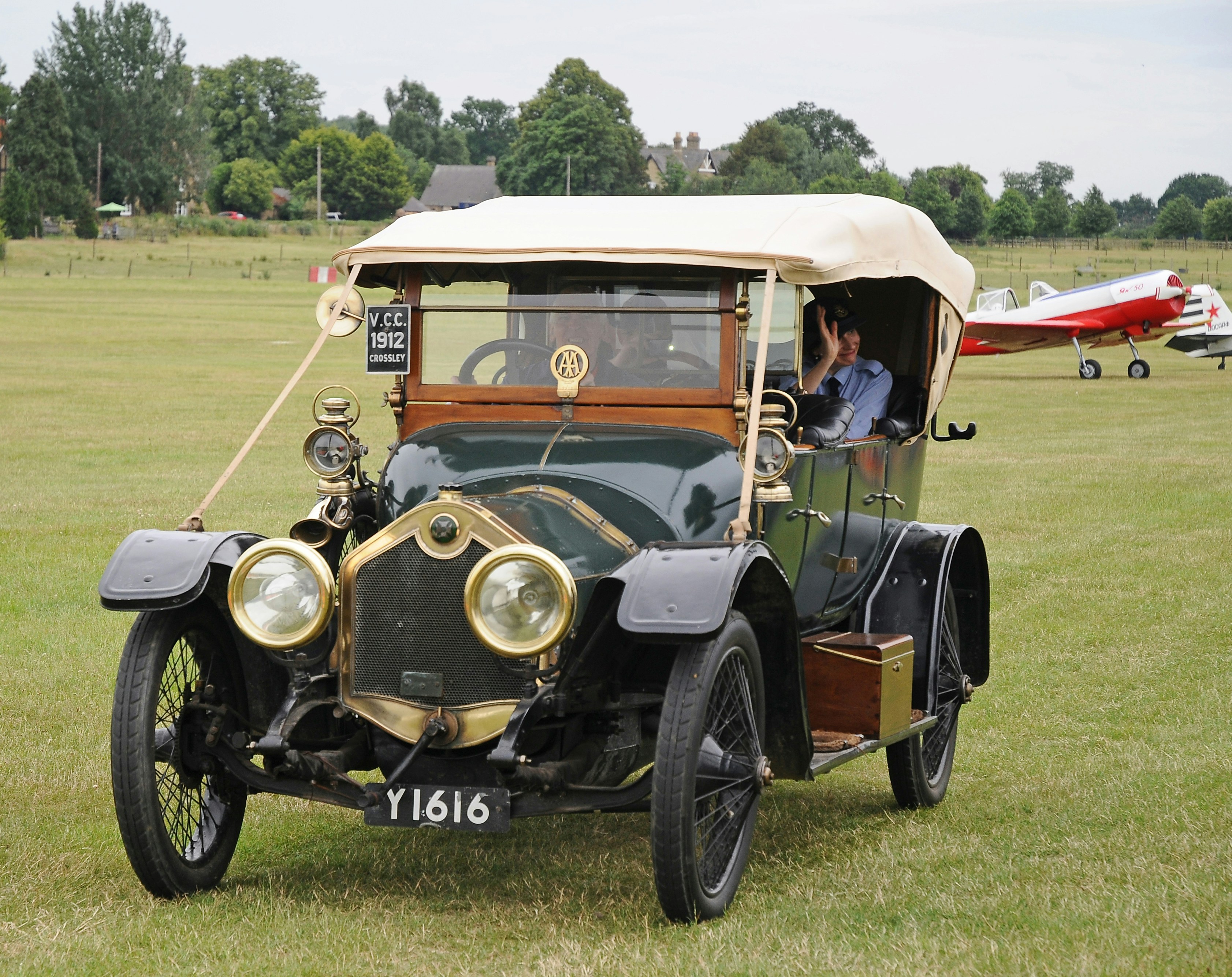 Un coche antiguo está aparcado en un campo