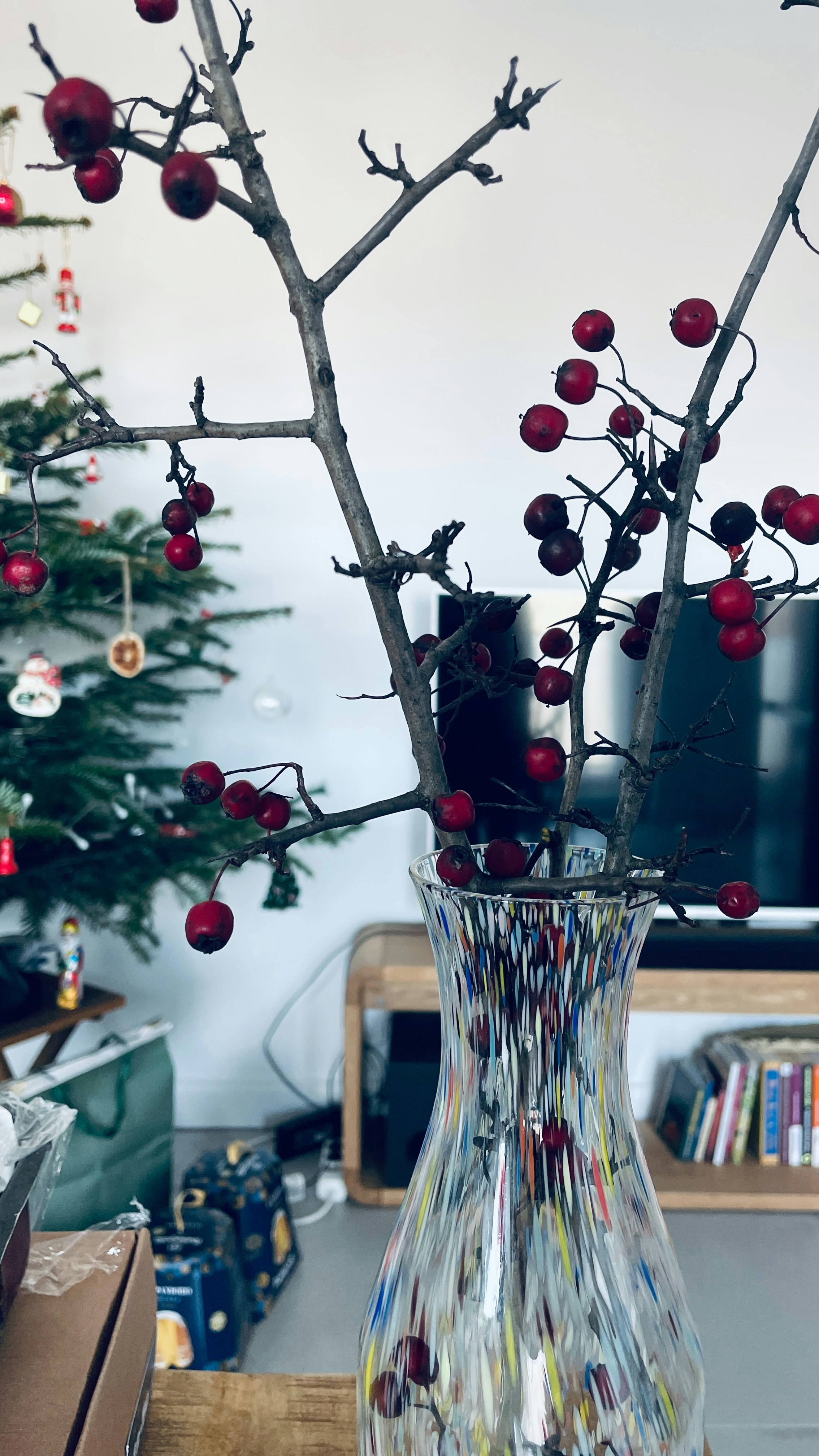 A vase filled with red berries on top of a table