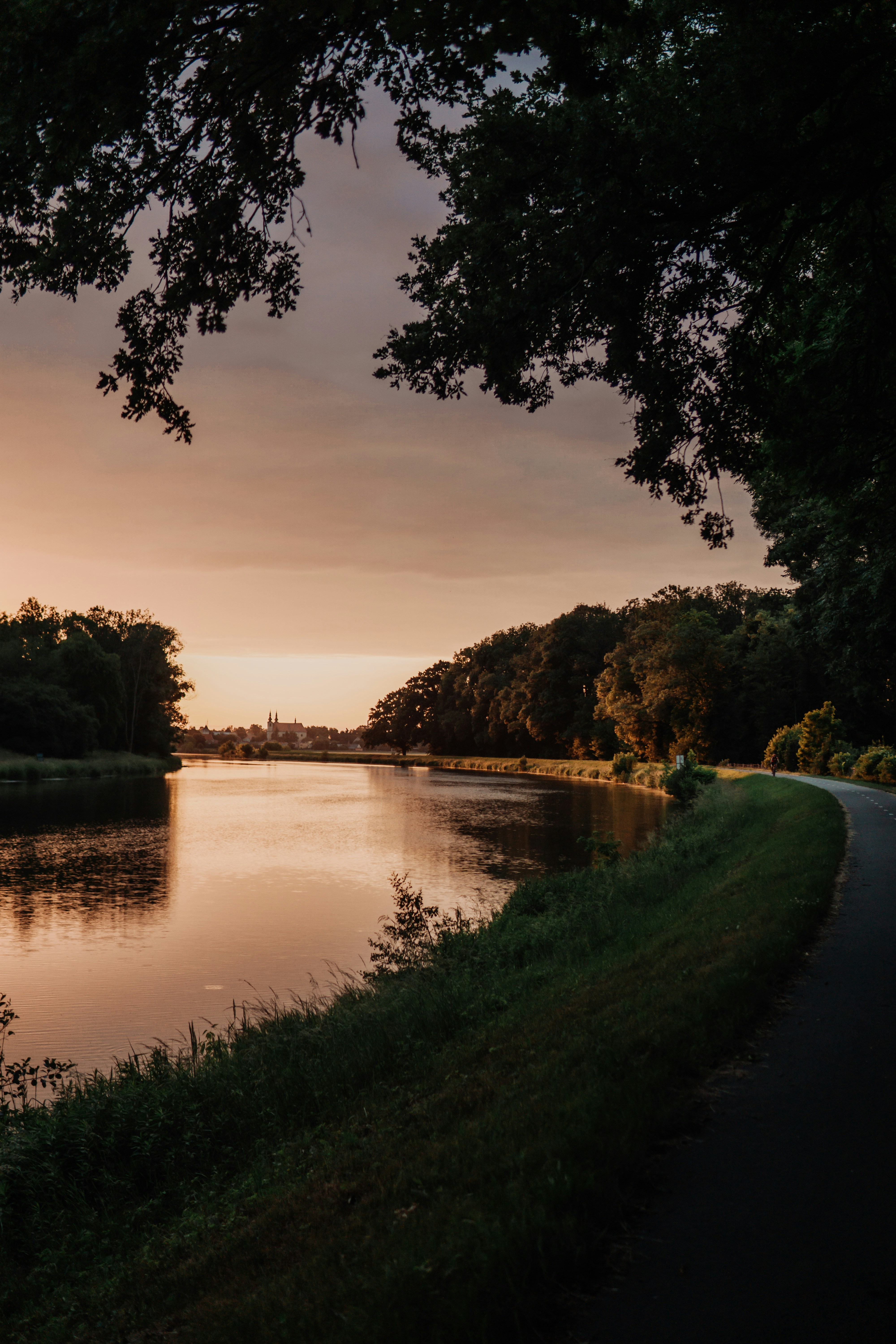 The sun is setting over the water of a river
