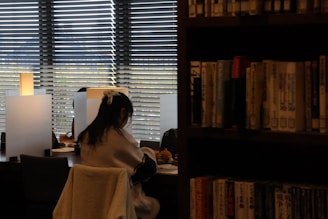 A woman sitting in a chair in front of a window