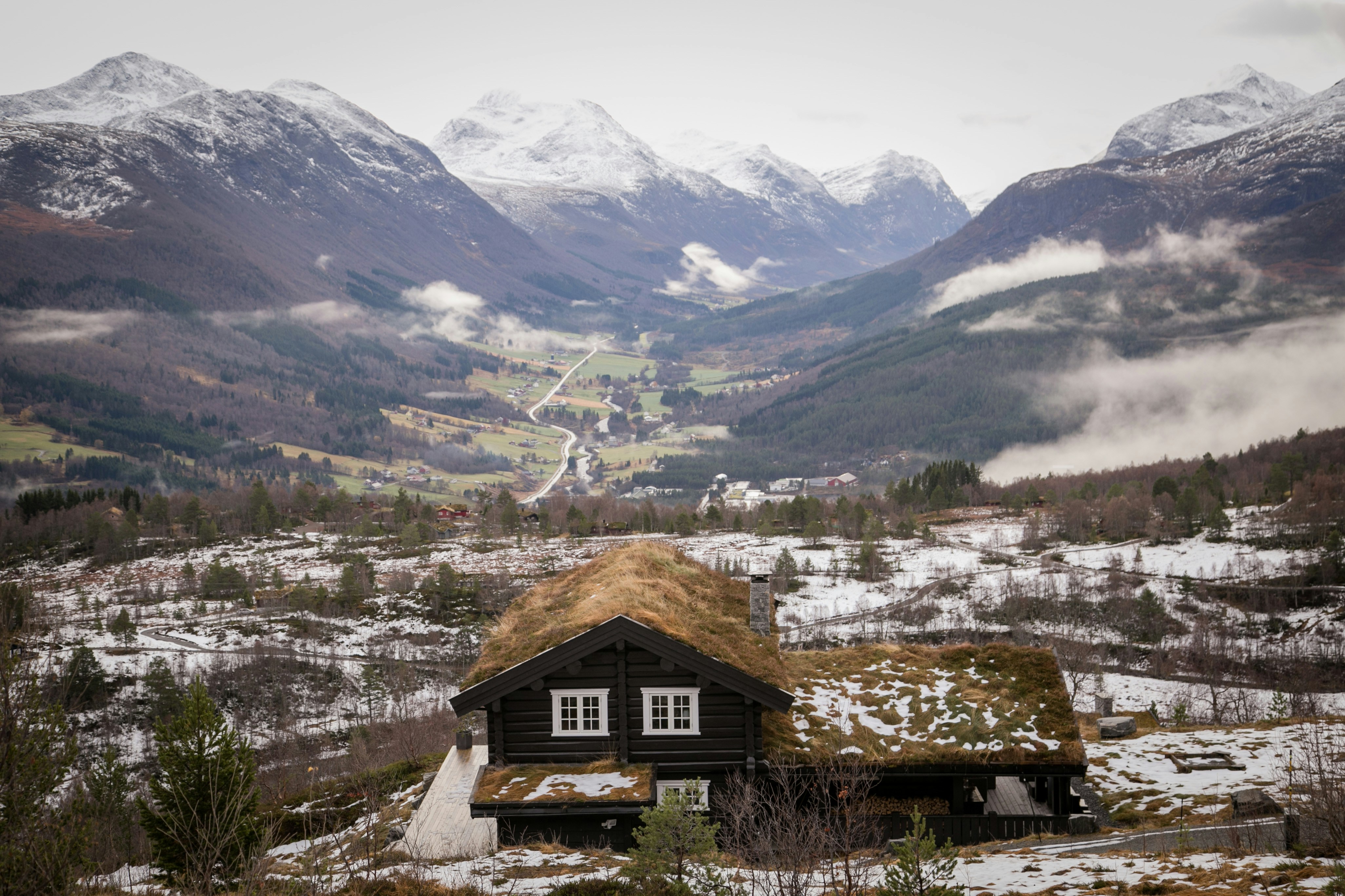 A small house with a thatched roof in the mountains