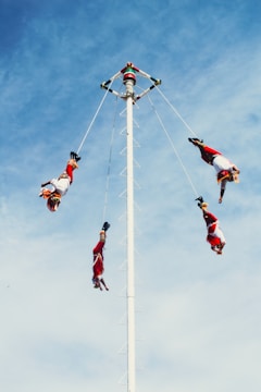 A group of people doing tricks on a pole