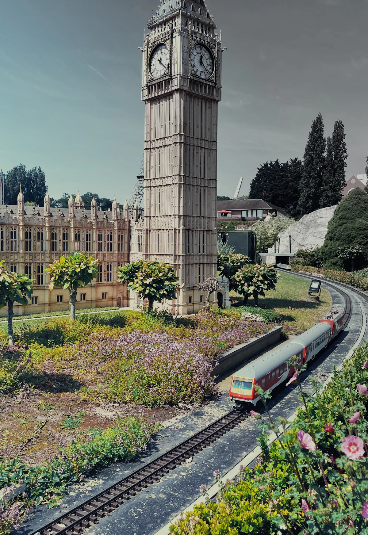 Miniature train passing a model clock tower