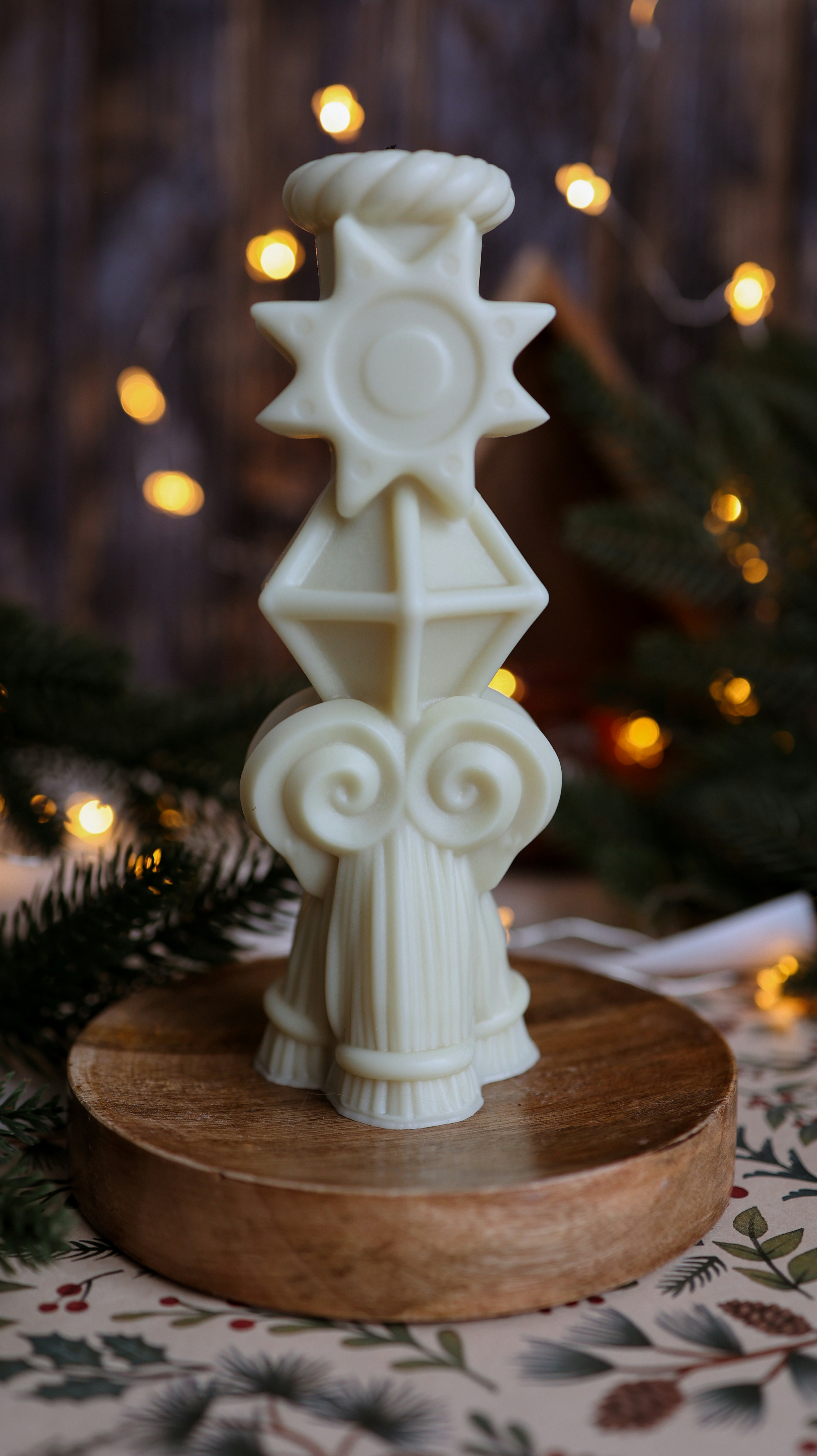 A white candle holder sitting on top of a wooden stand