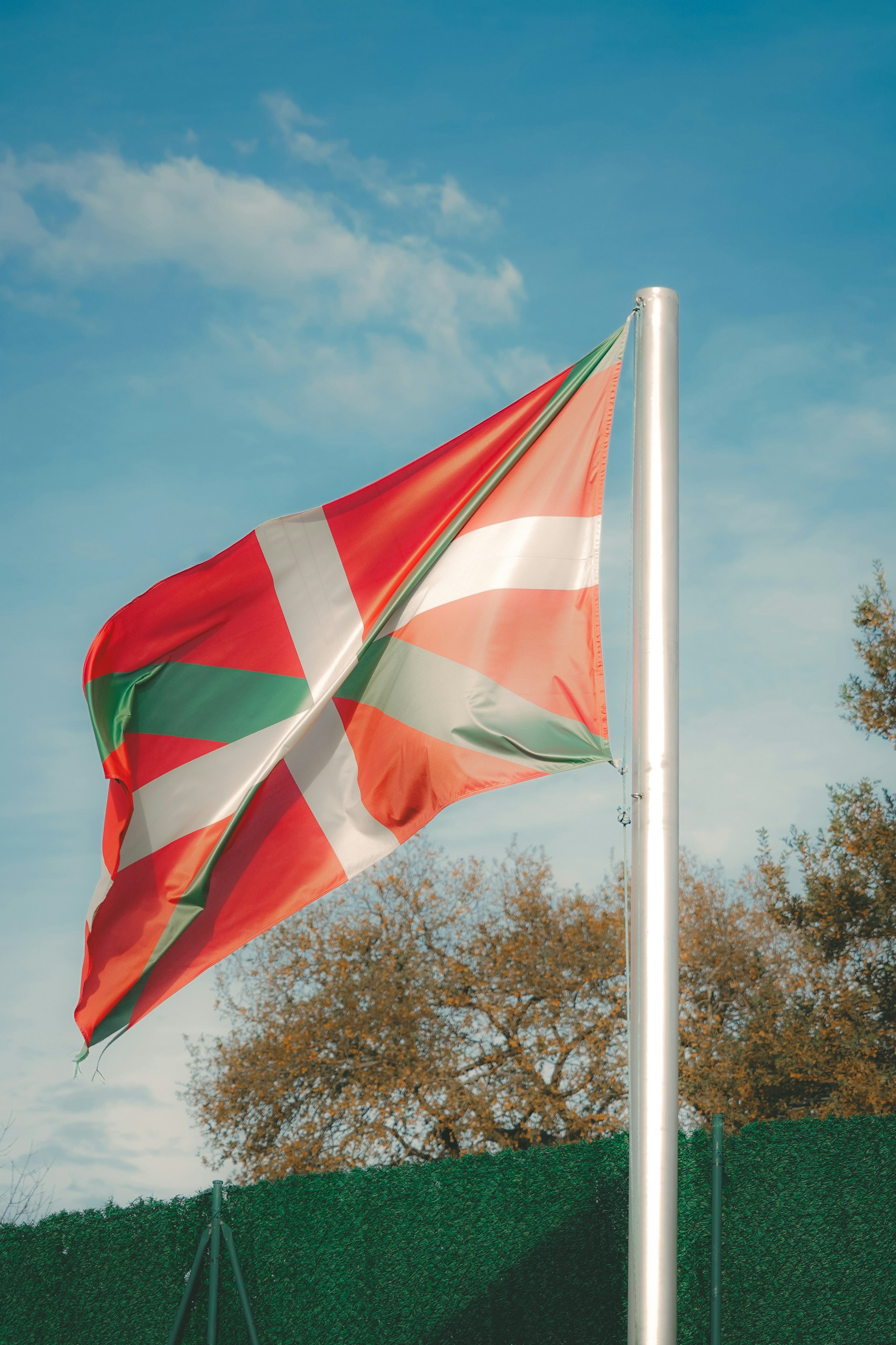 A red, white and green flag on a pole