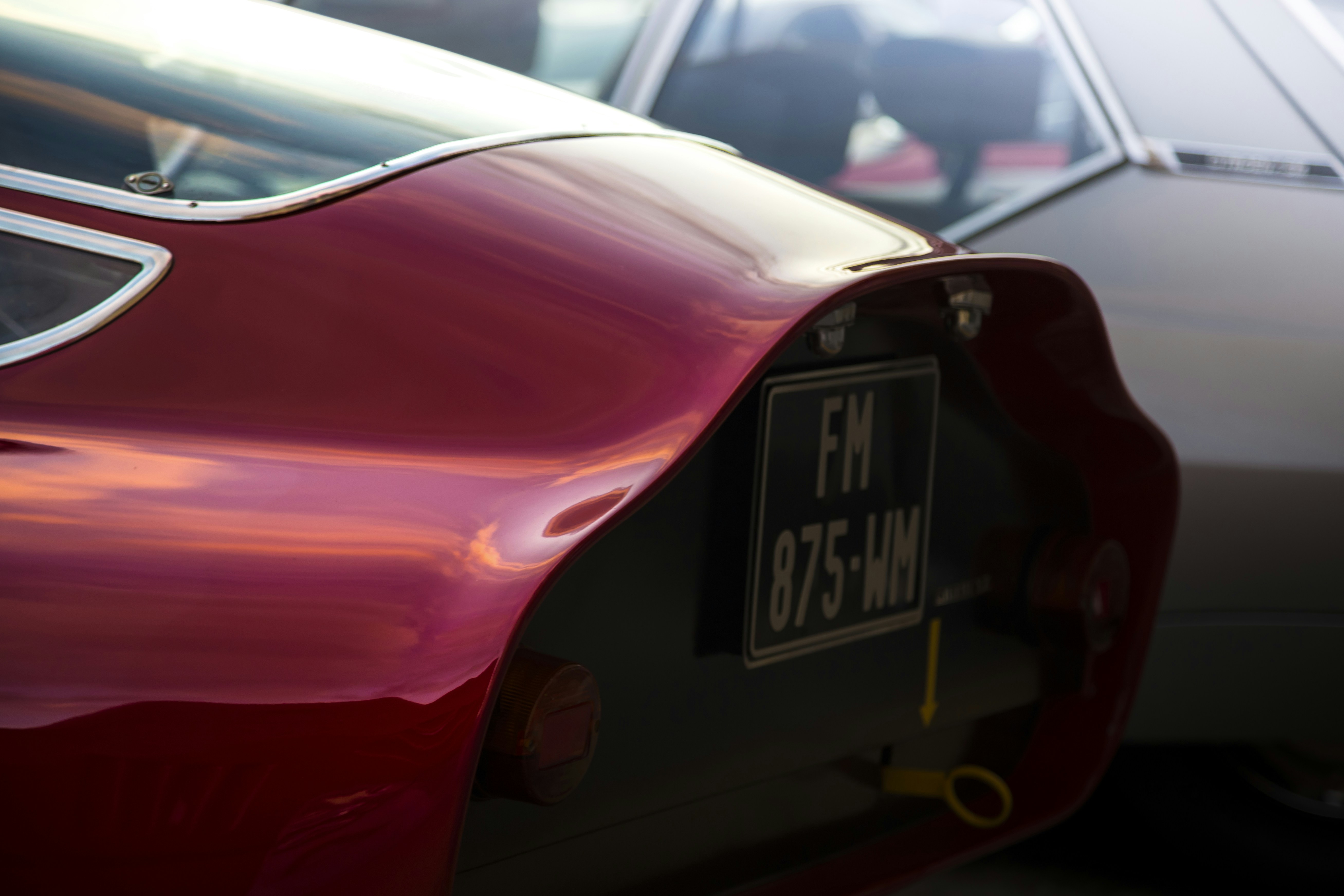 A close up of a red car with a license plate