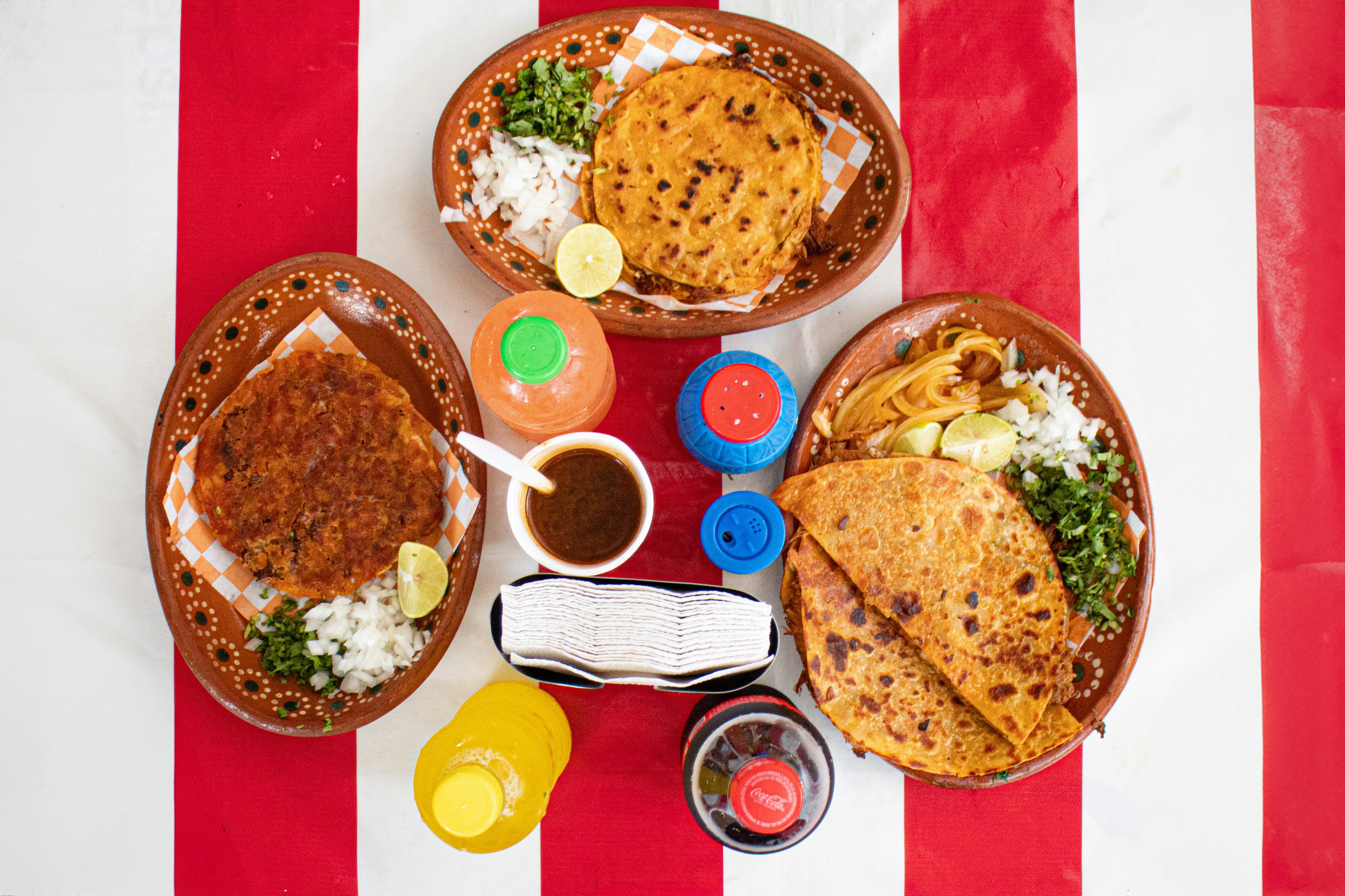 A table topped with plates of food on top of a red and white striped table