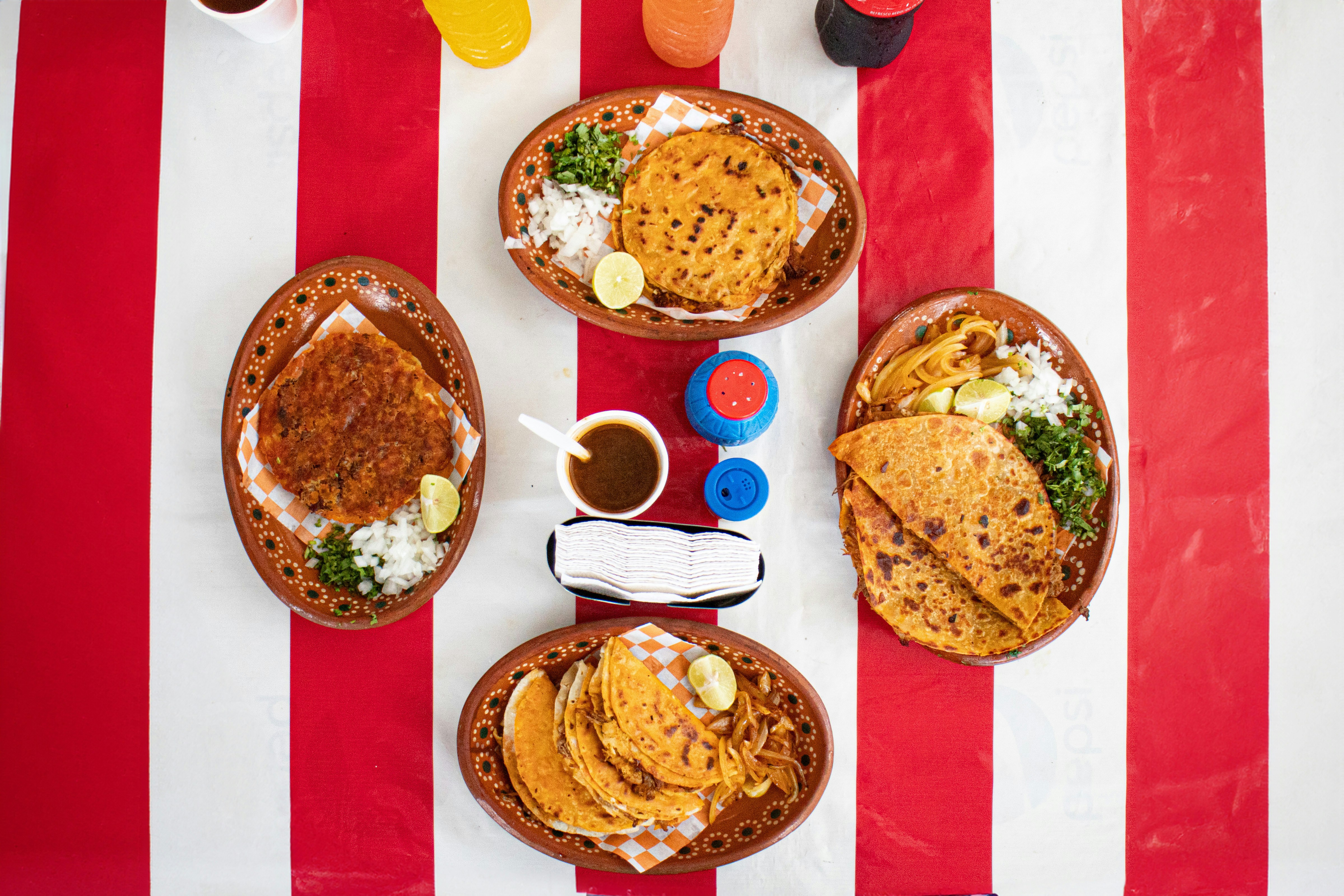 A table topped with plates of food on top of a red and white striped table
