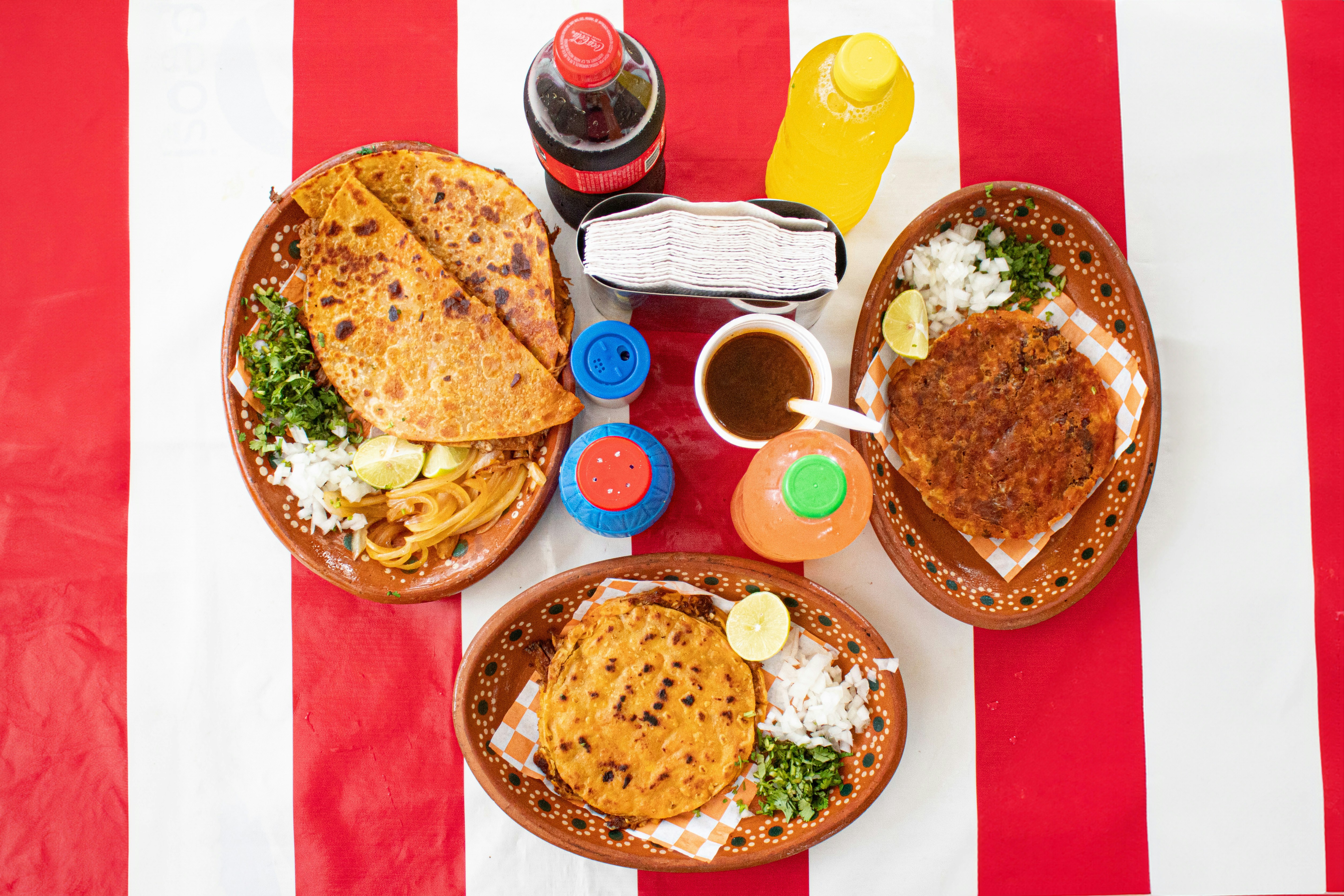 A table topped with plates of food on top of a red and white striped table