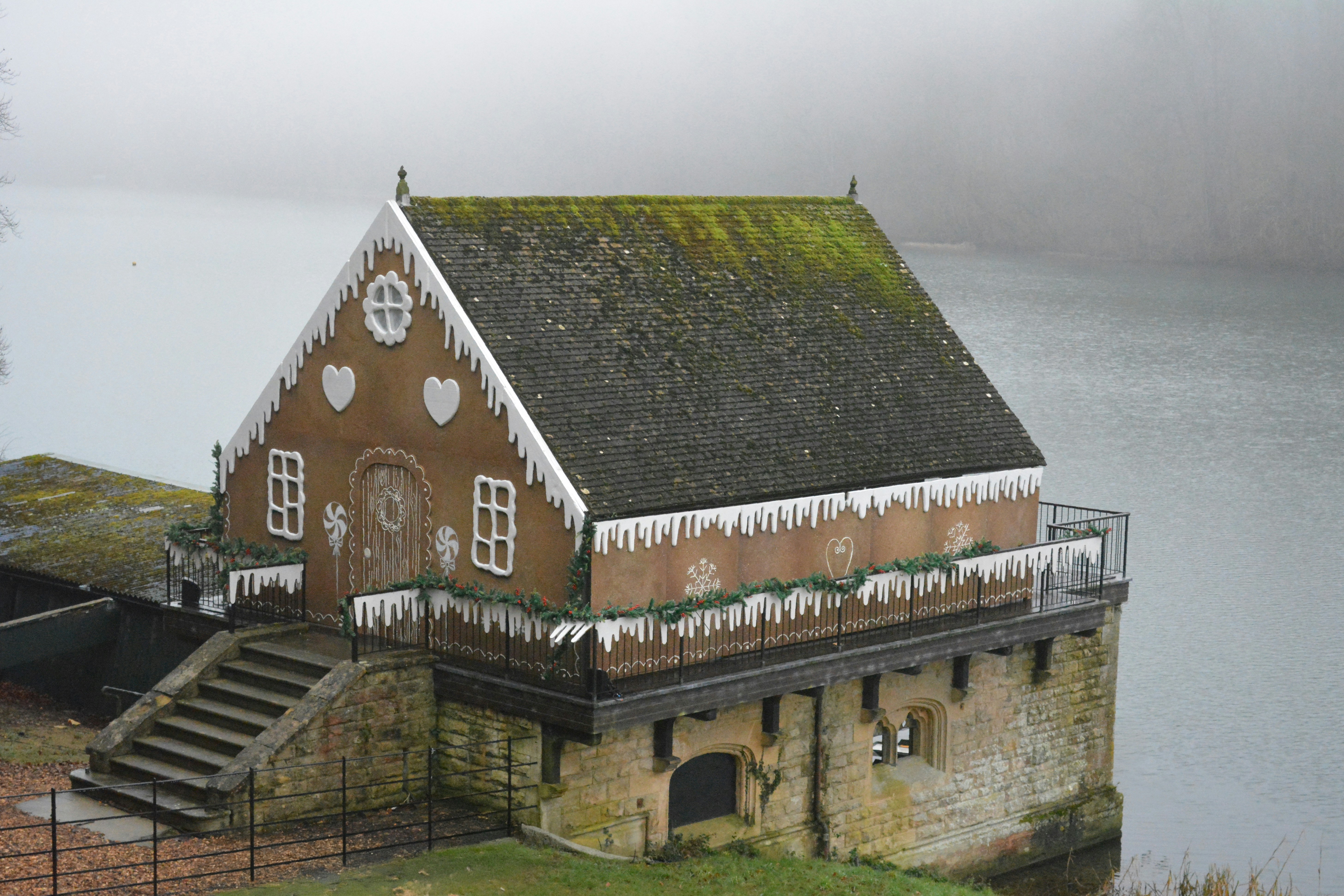 A house with a green roof next to a body of water