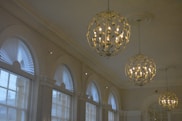 A room filled with lots of windows and a chandelier hanging from the ceiling