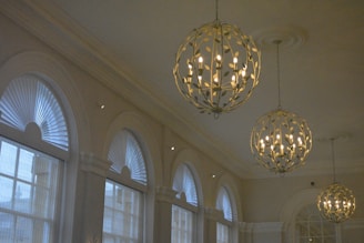 A room filled with lots of windows and a chandelier hanging from the ceiling