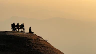 A group of people sitting on top of a hill