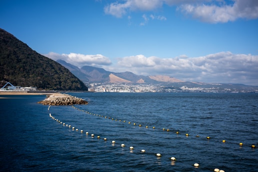 A body of water surrounded by mountains and clouds