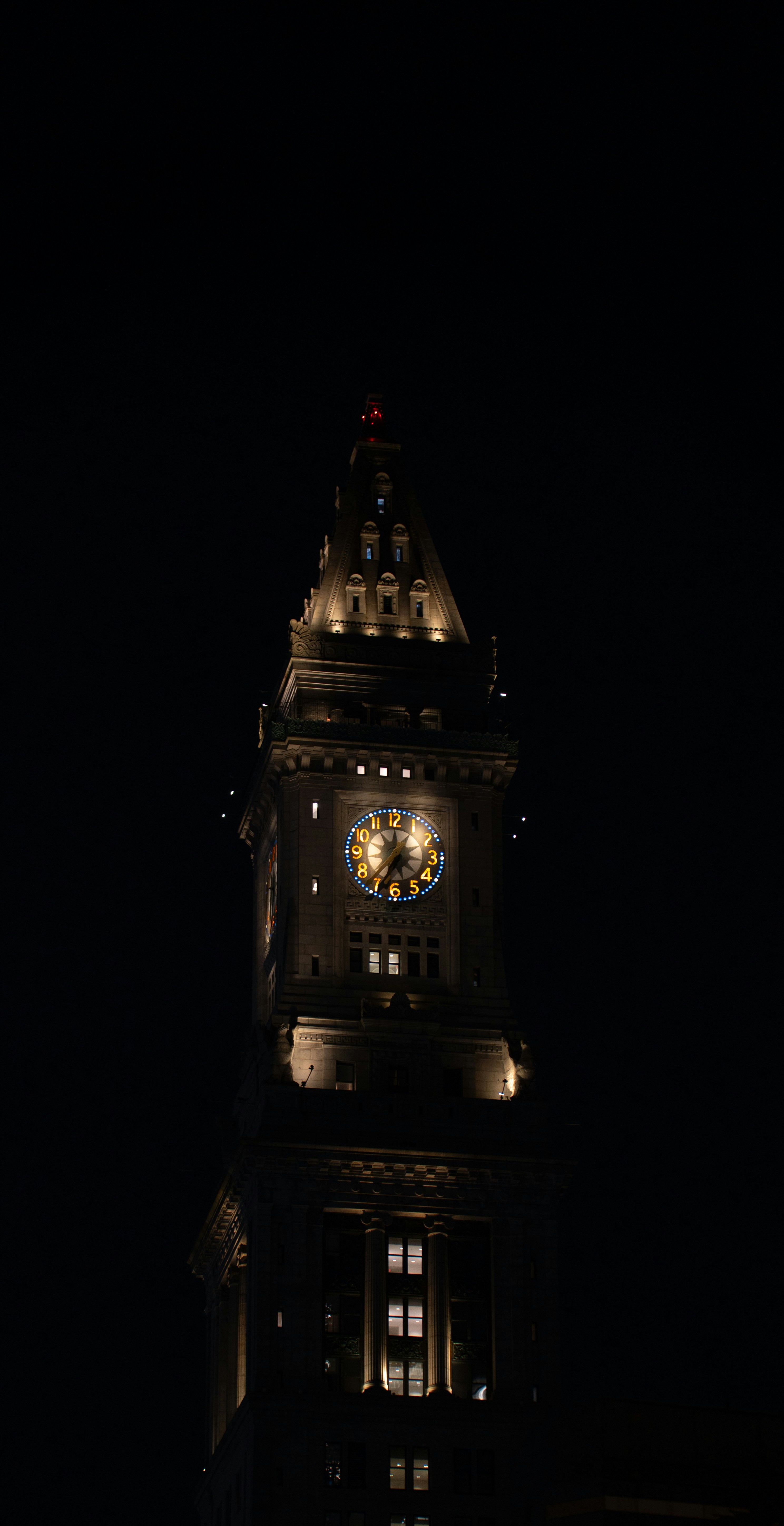 A large clock tower lit up at night
