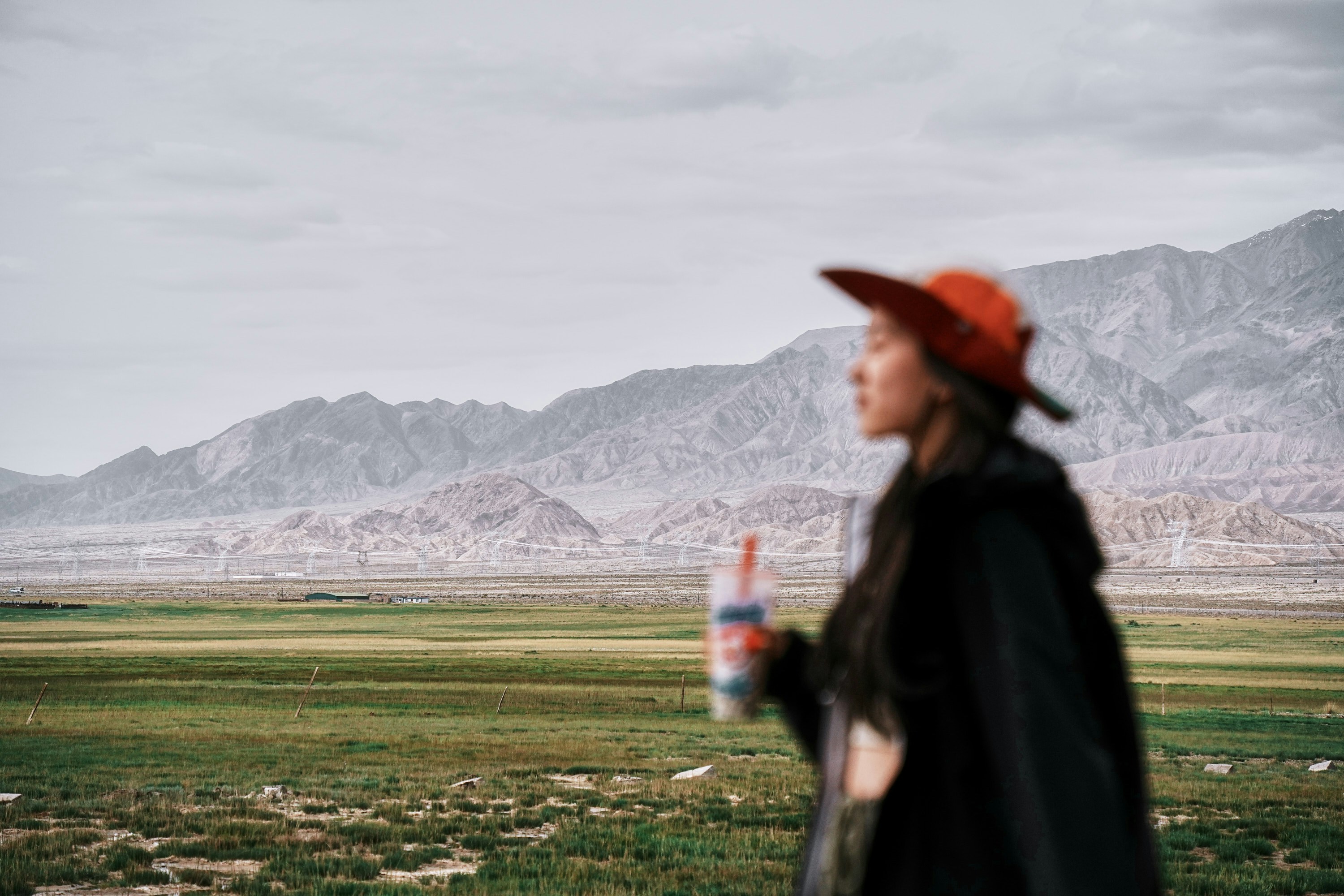 A woman with a red hat and a drink in her hand