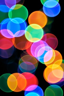 A blurry photo of colorful lights on a black background