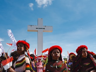 A group of people standing in front of a cross