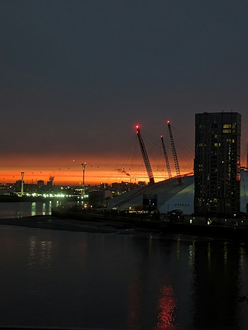 Le dôme de The O2 et ses mâts éclairés de rouge au coucher du soleil, au bord de la Tamise à Londres