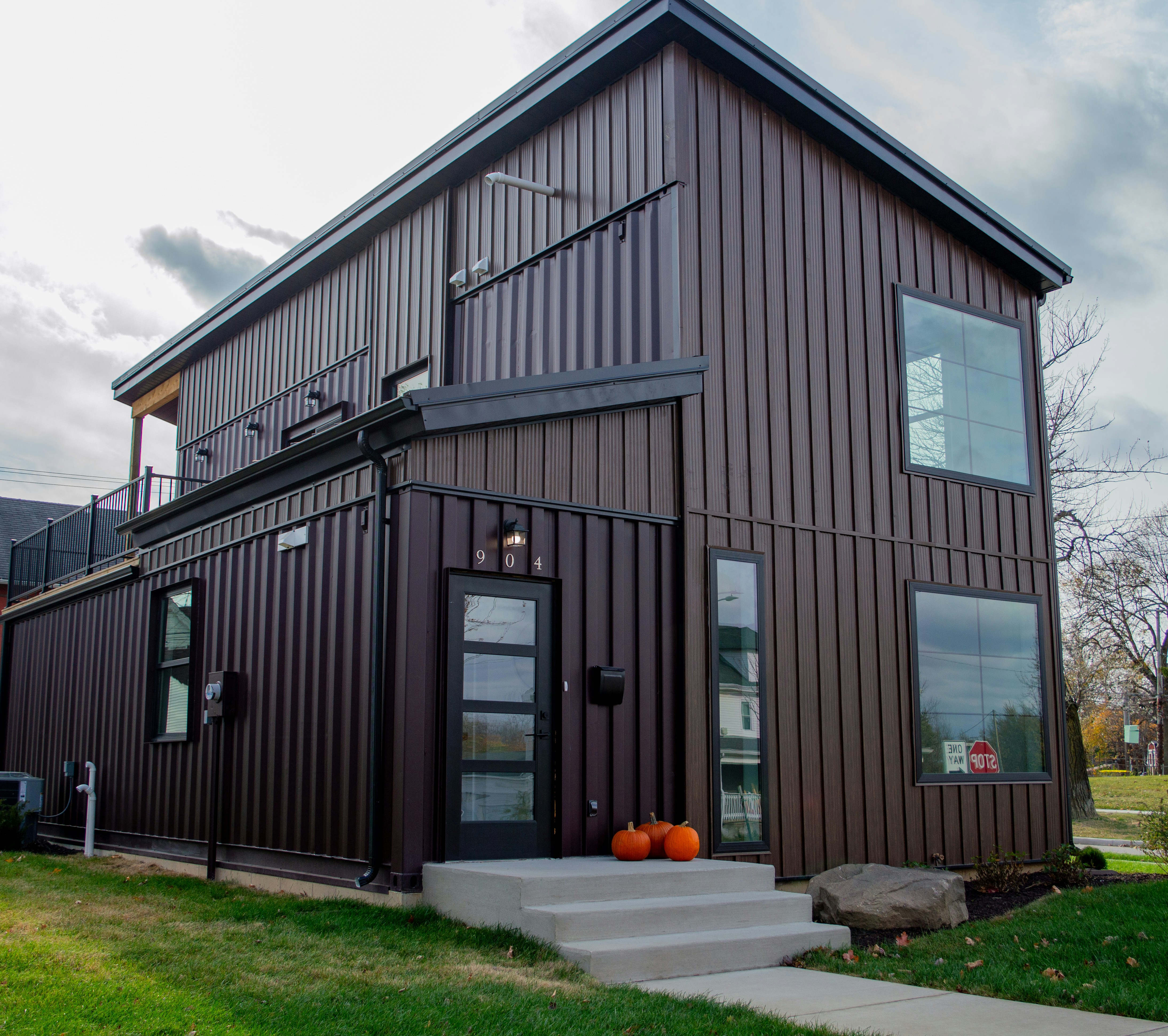 A large brown house sitting on top of a lush green field