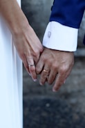 A close up of two people holding hands