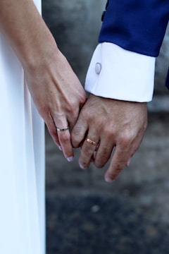 A close up of two people holding hands