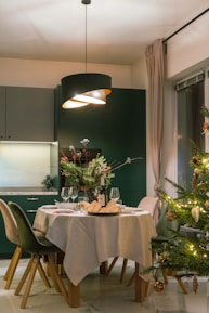 A dining room with a christmas tree in the corner