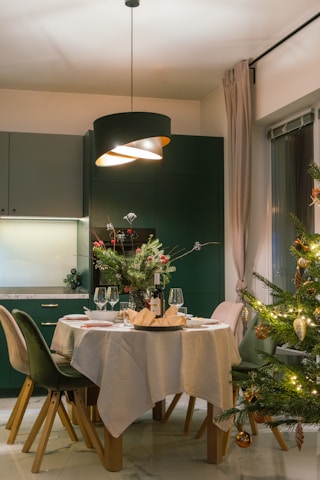 A dining room with a christmas tree in the corner