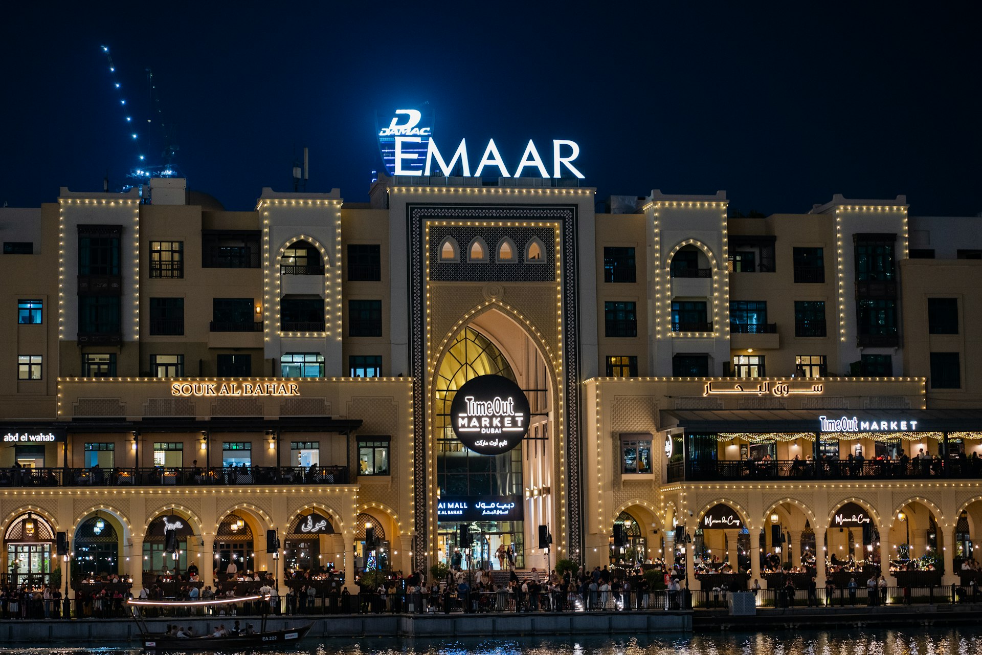 A large building with a lit up sign on top of it