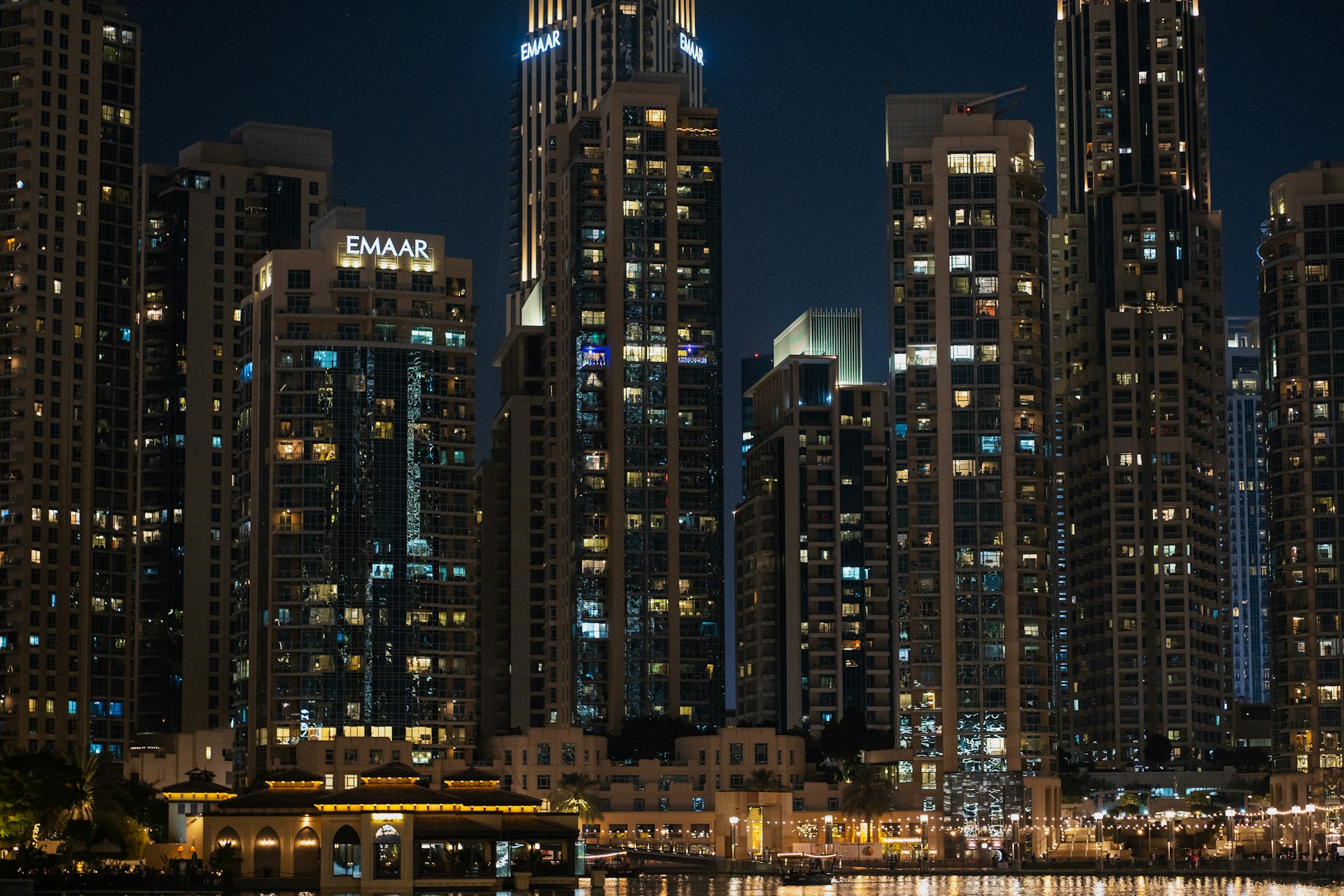 A city skyline at night with a boat in the water