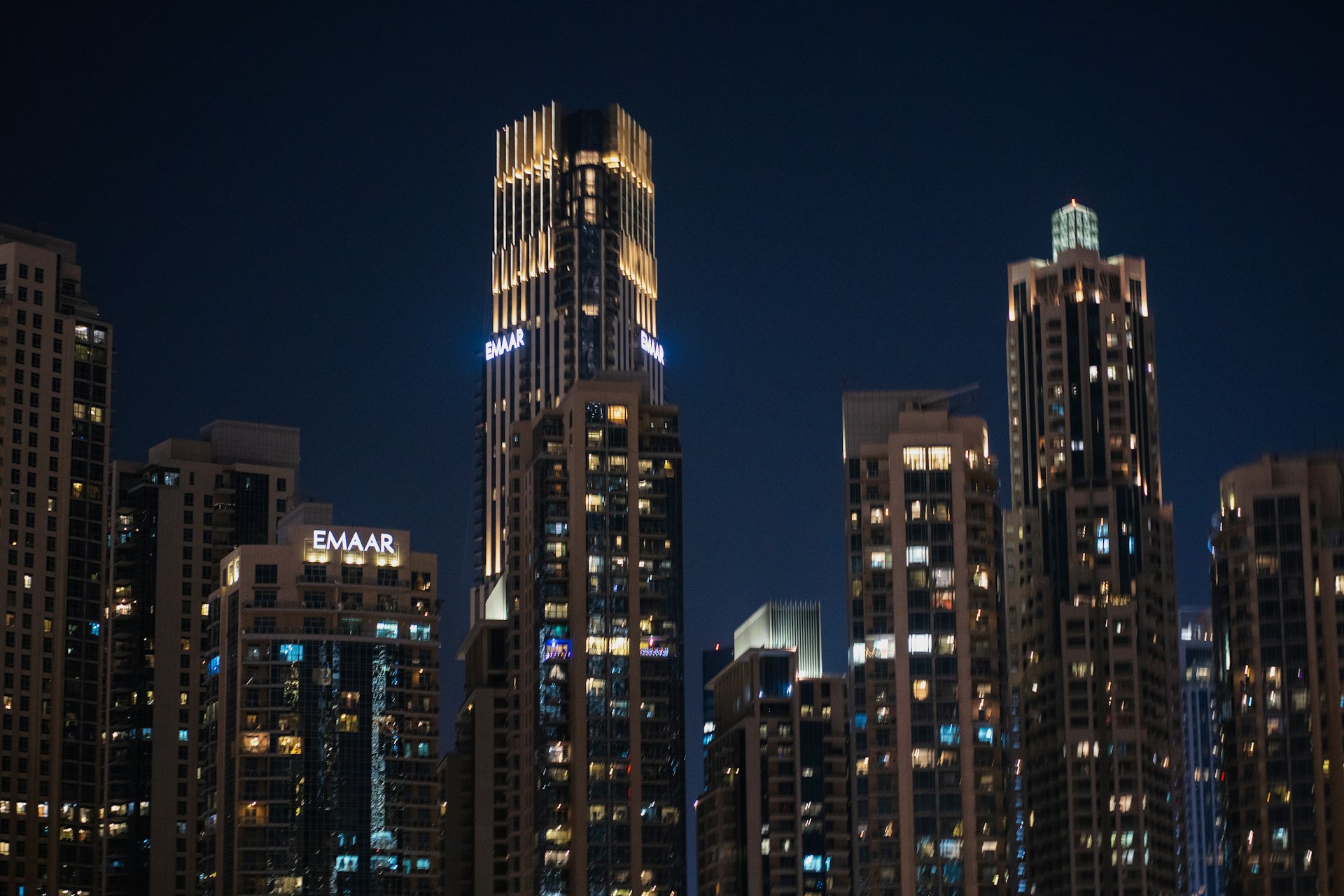 A city skyline at night with a boat in the water