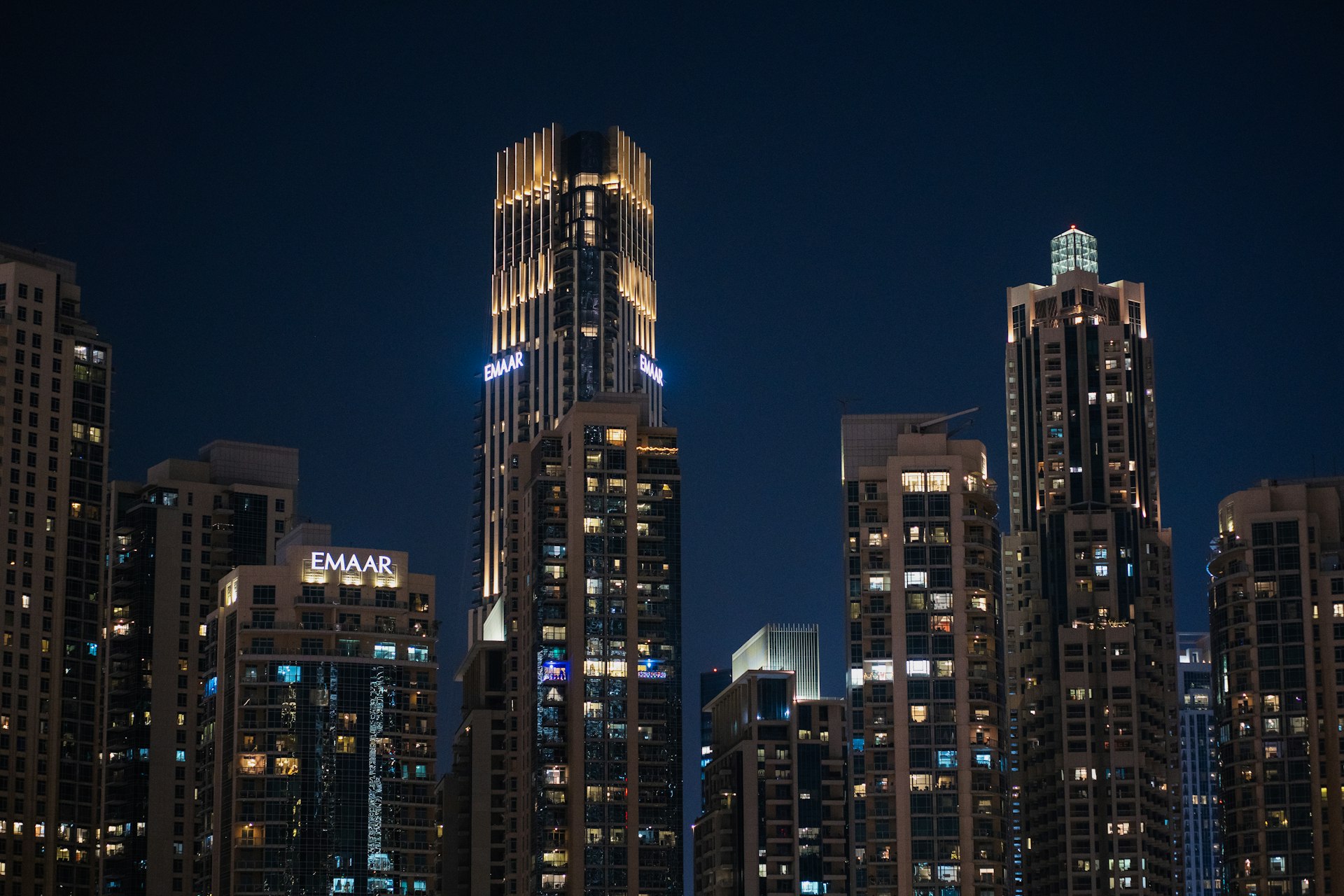 A city skyline at night with a boat in the water