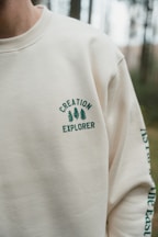 A man with a beard wearing a white sweatshirt