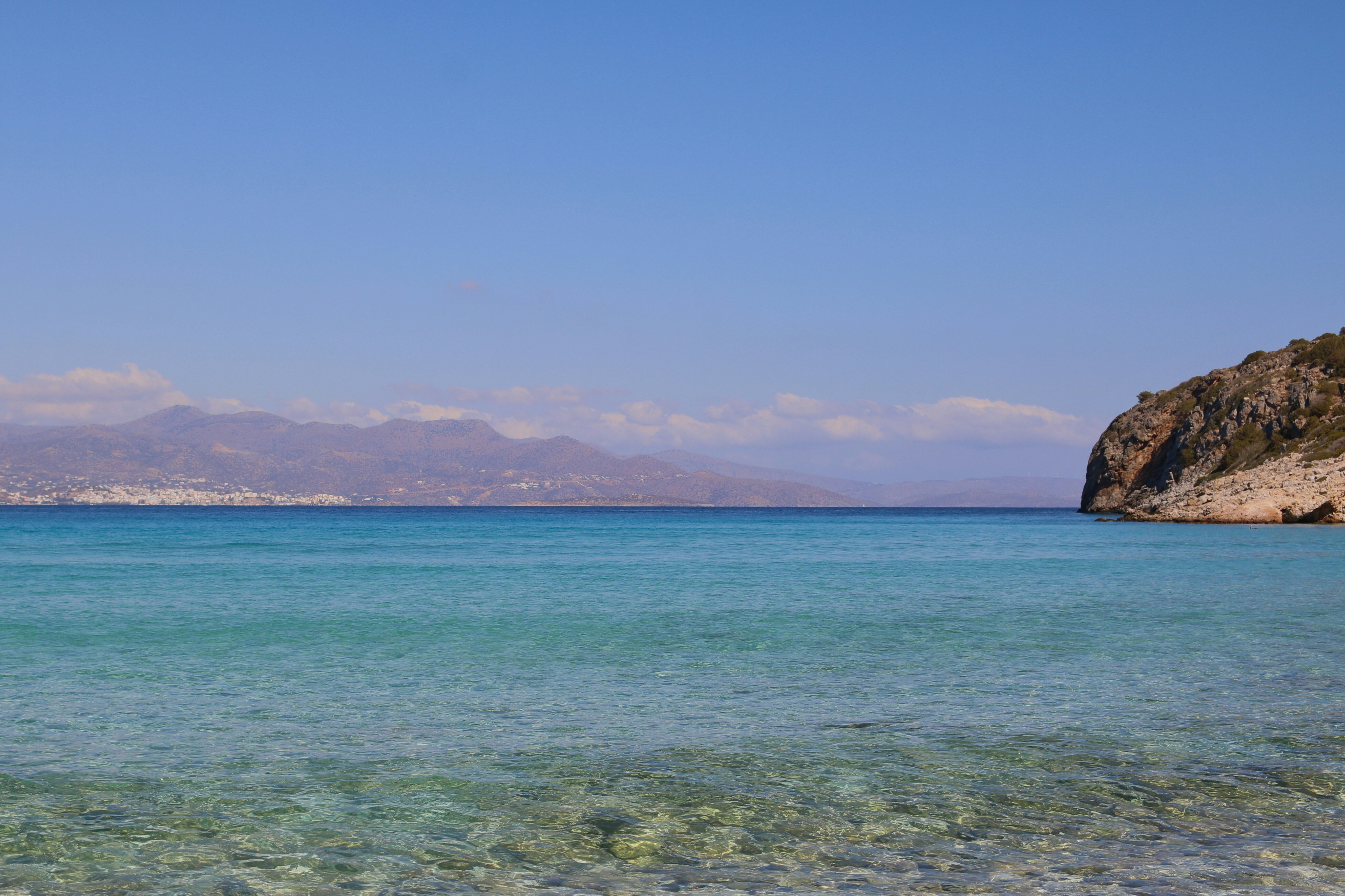A body of water with a mountain in the background, 50 shades of blue