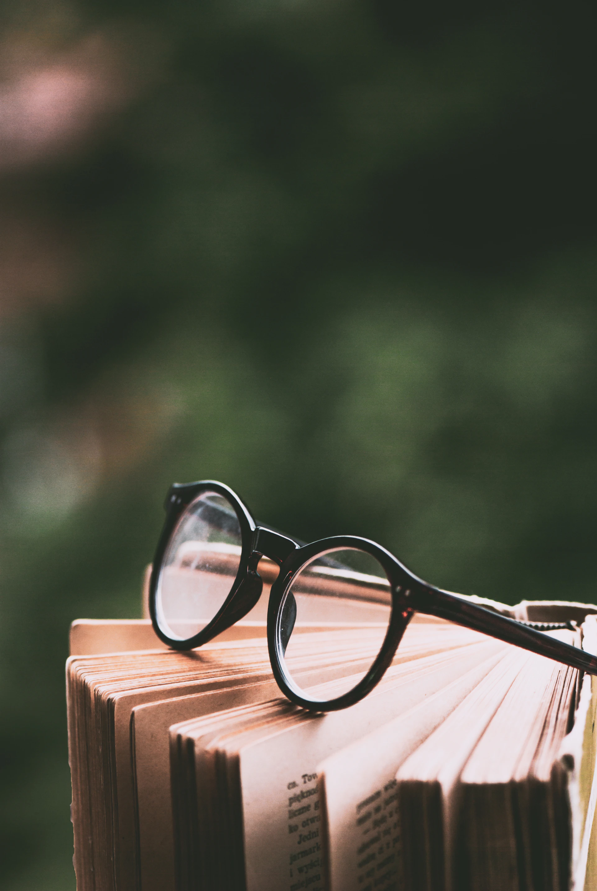 A stack of books with a pair of glasses on top