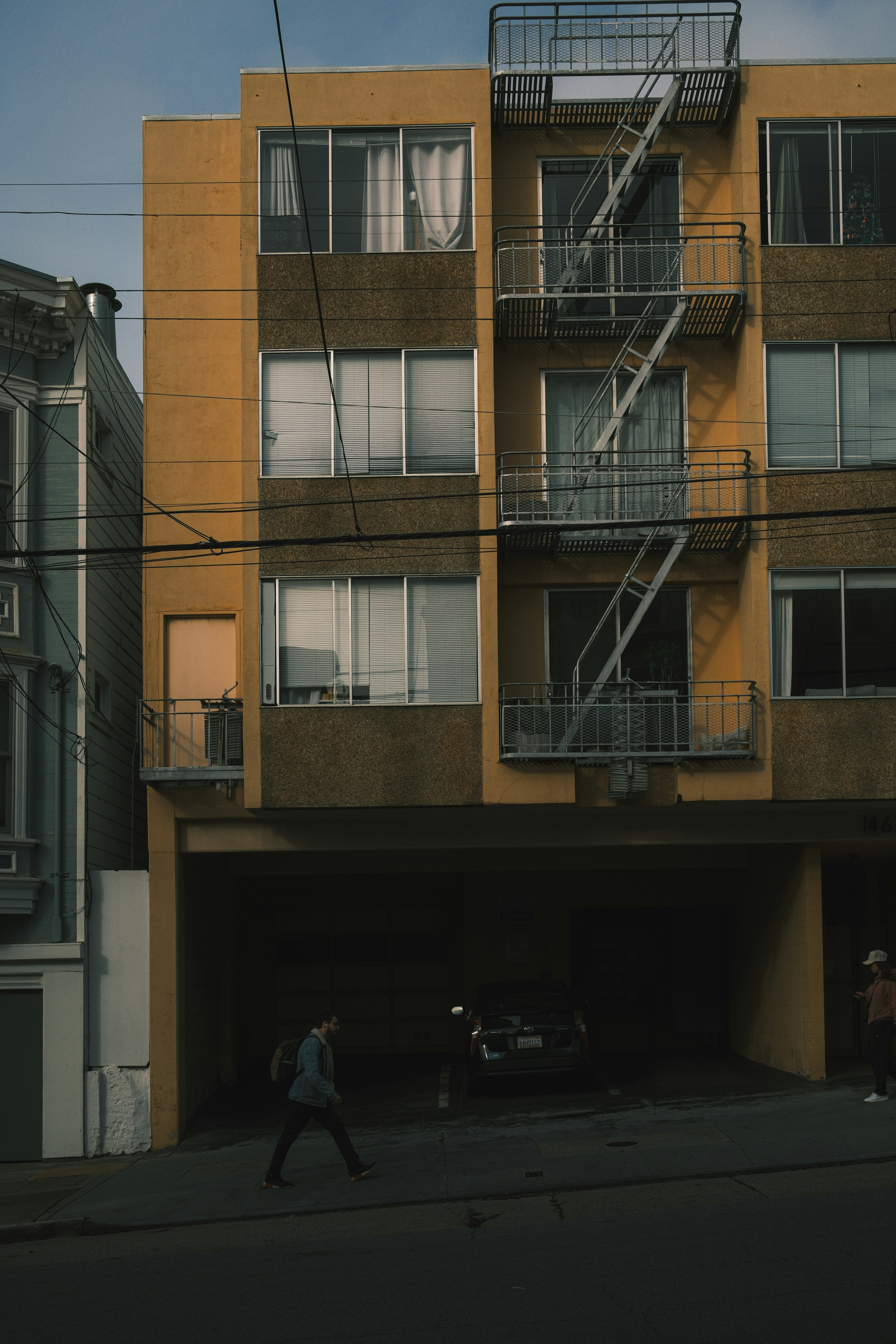 고층 건물 앞 거리를 걷고 있는 두 사람