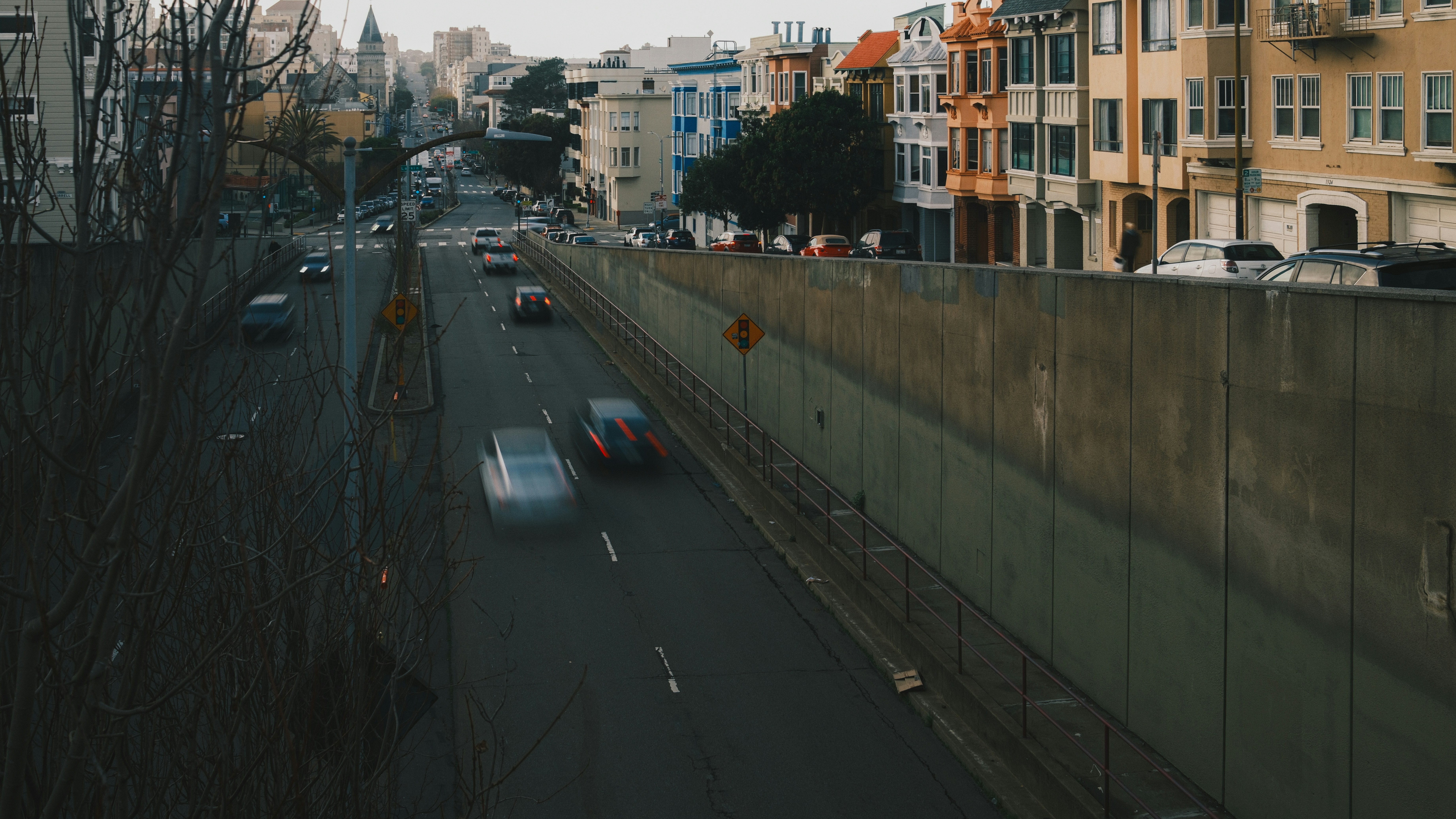 A city street filled with lots of traffic next to tall buildings