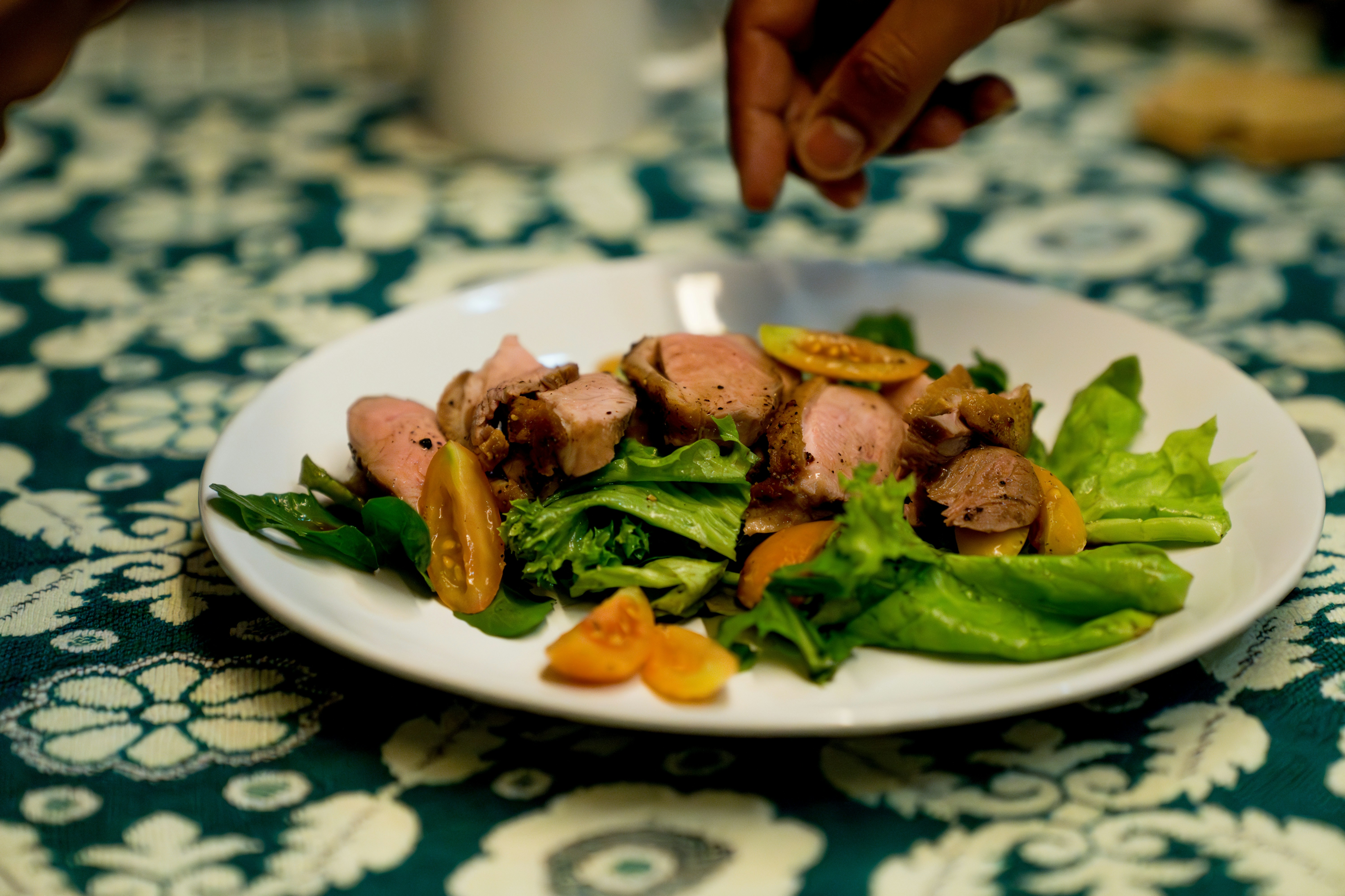 A white plate topped with meat and veggies