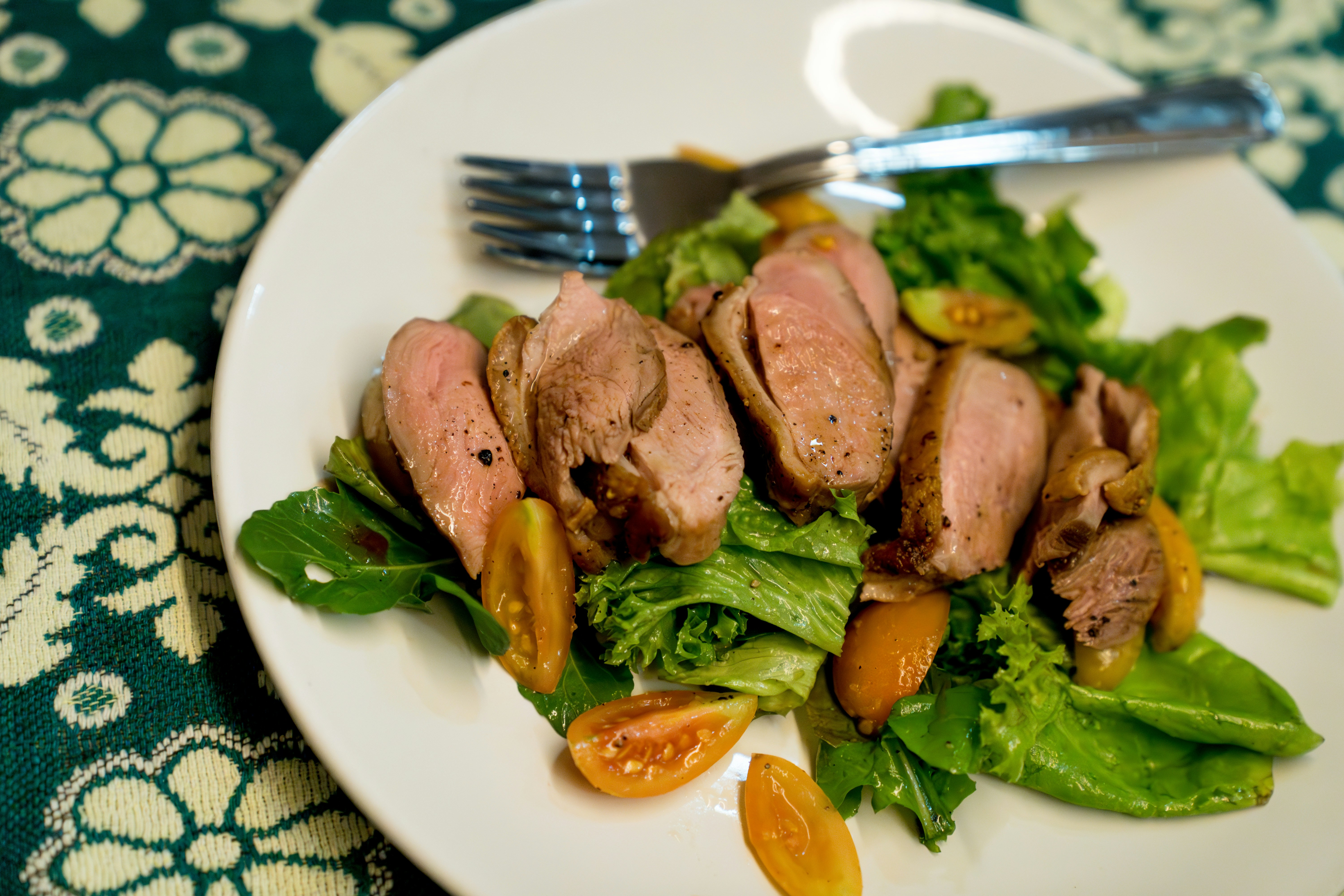 A white plate topped with meat and veggies