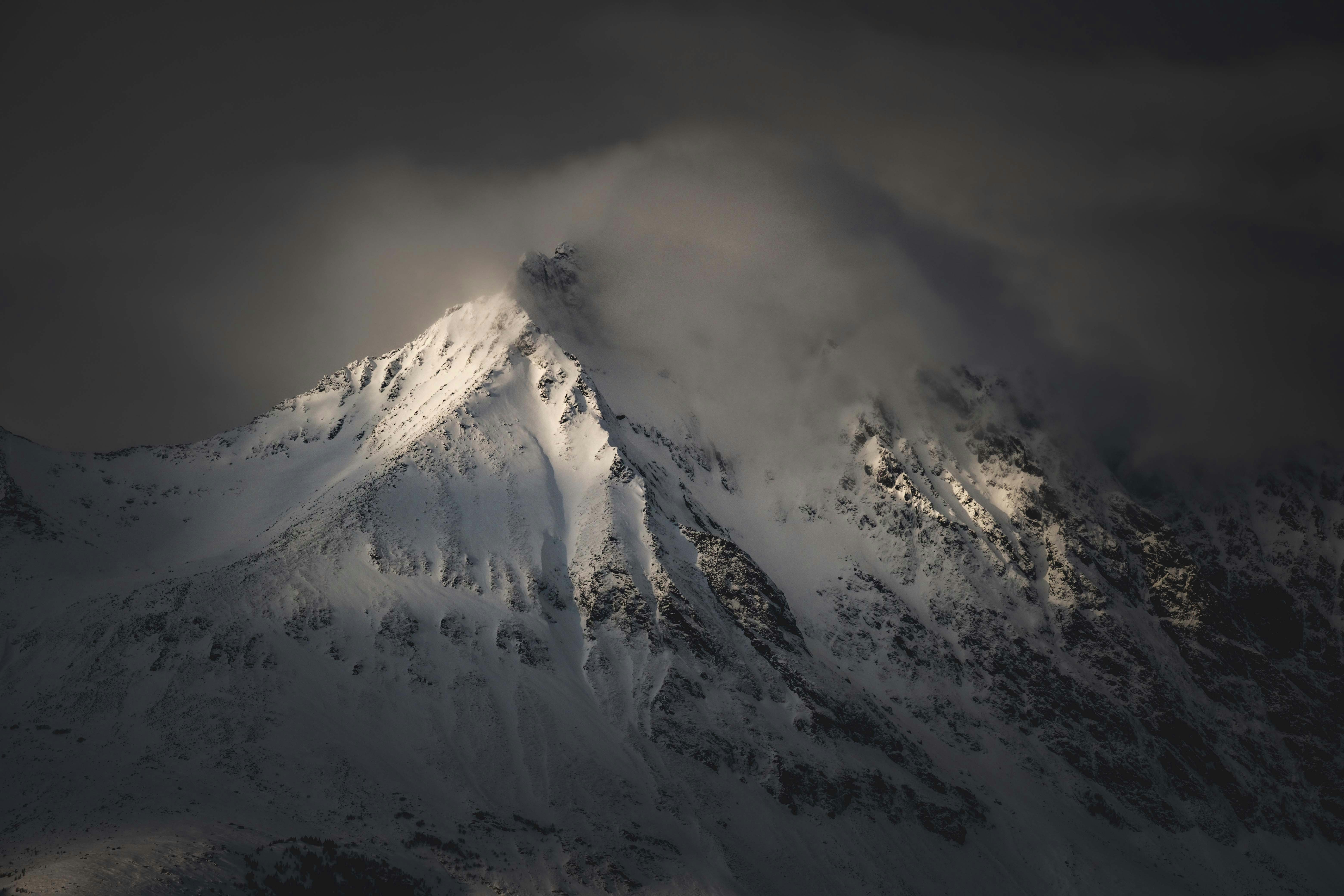 구름 낀 하늘 아래 눈 덮인 산