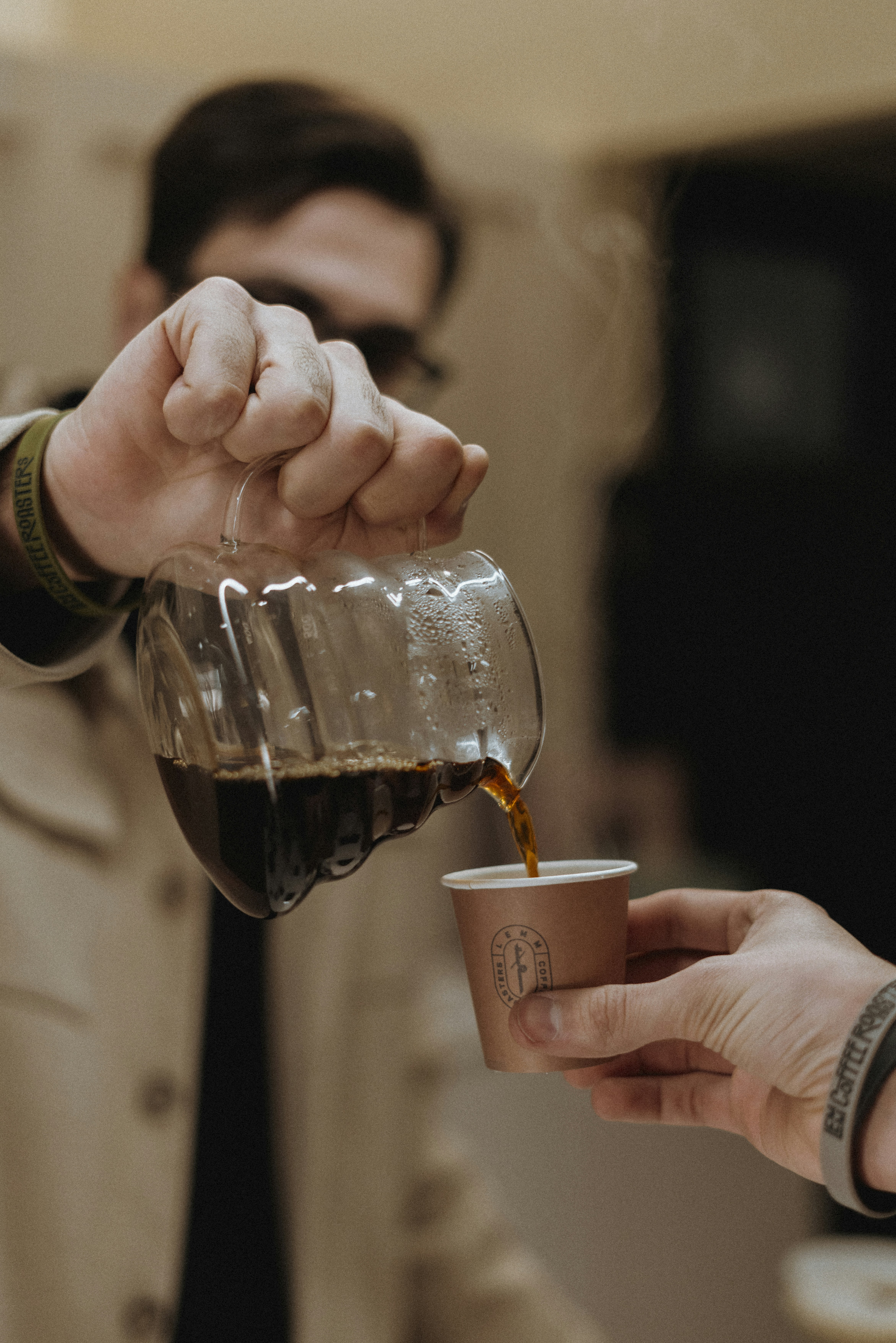 A man pouring a cup of coffee into another man's hand