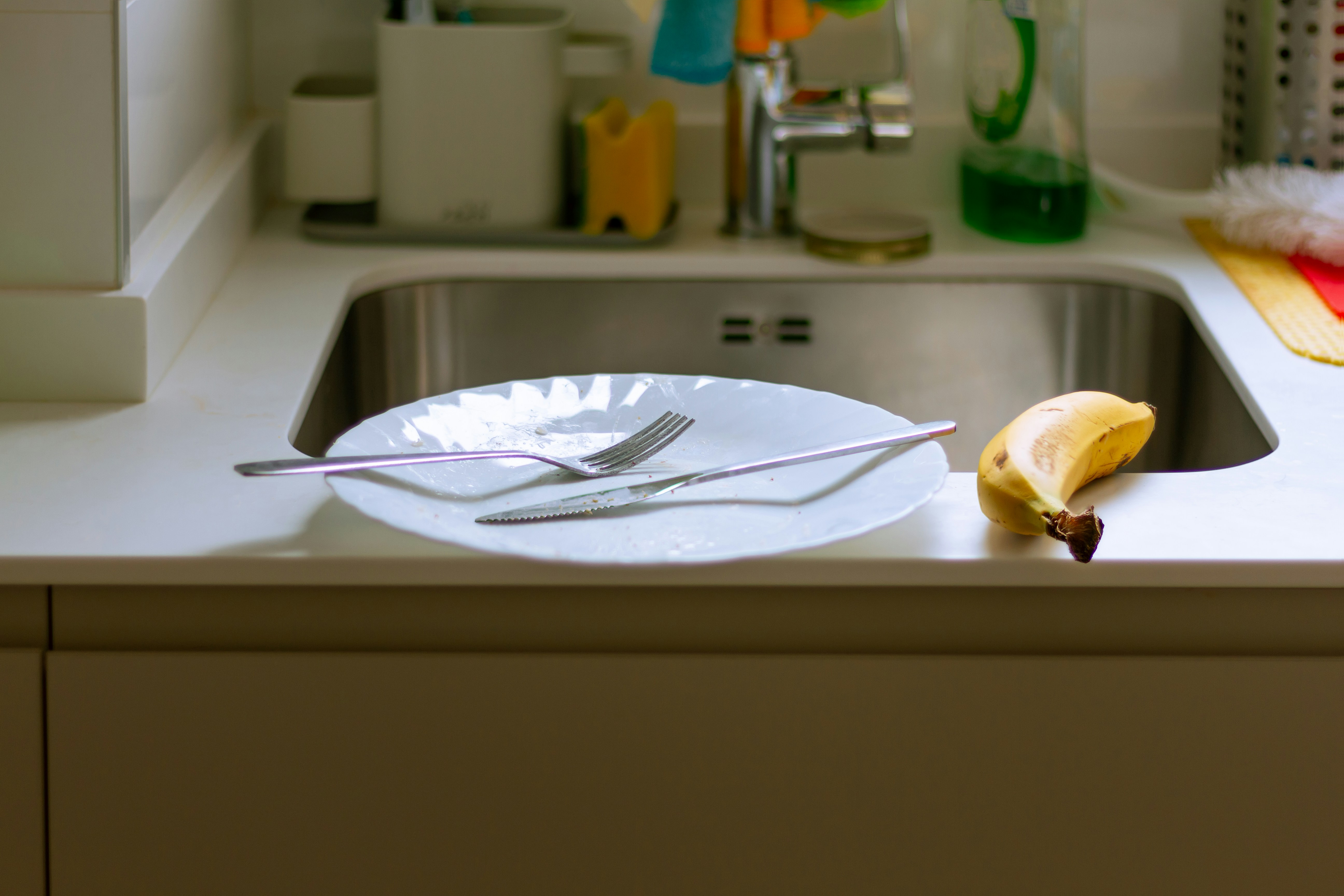 A plate with a knife and fork on a kitchen counter