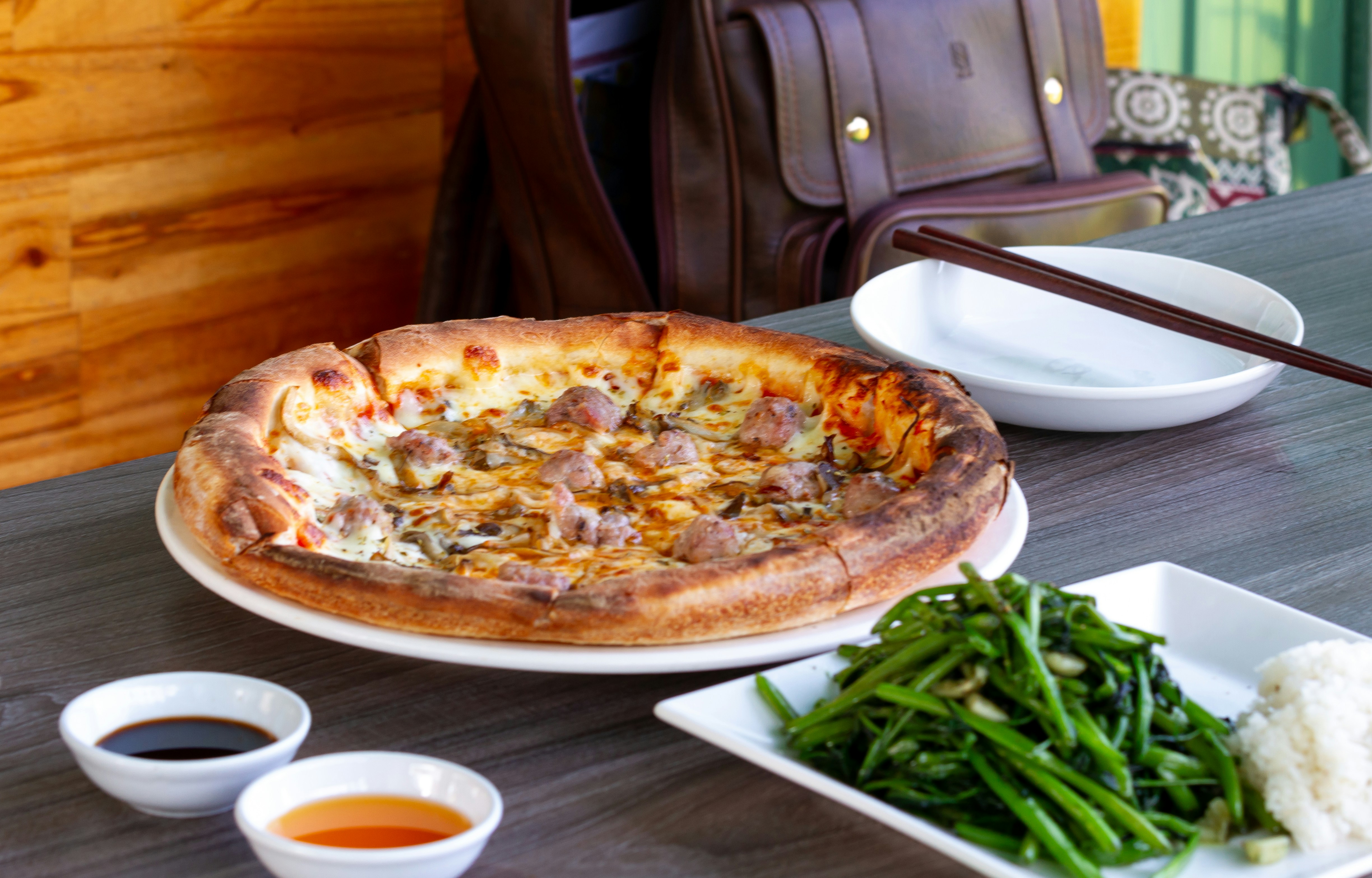 A table topped with plates of food and a pizza