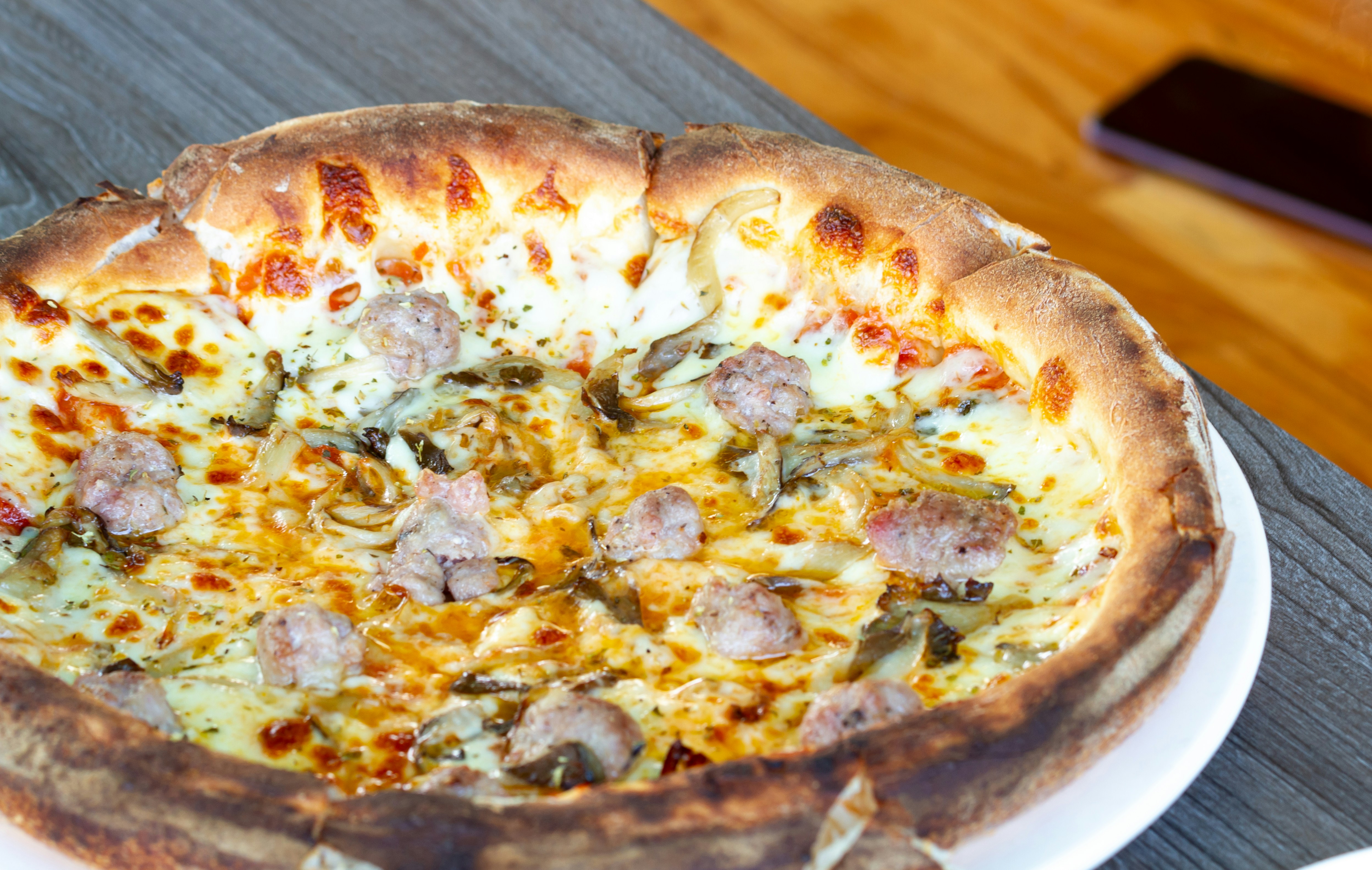 A pizza sitting on top of a white plate on a table