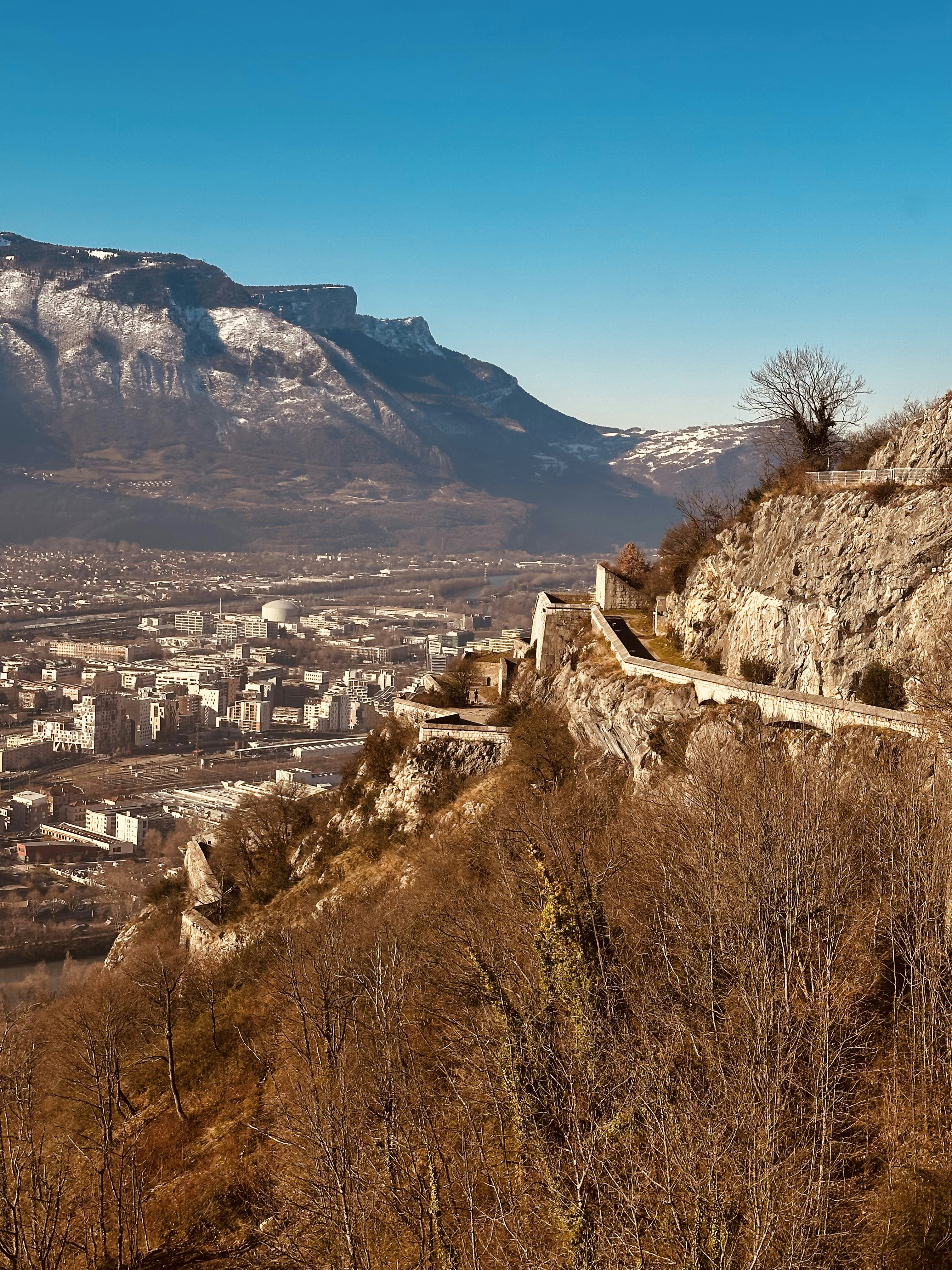 A view of a city and mountains from the top of a hill
