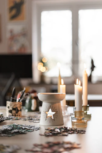 A table topped with lots of candles next to a window