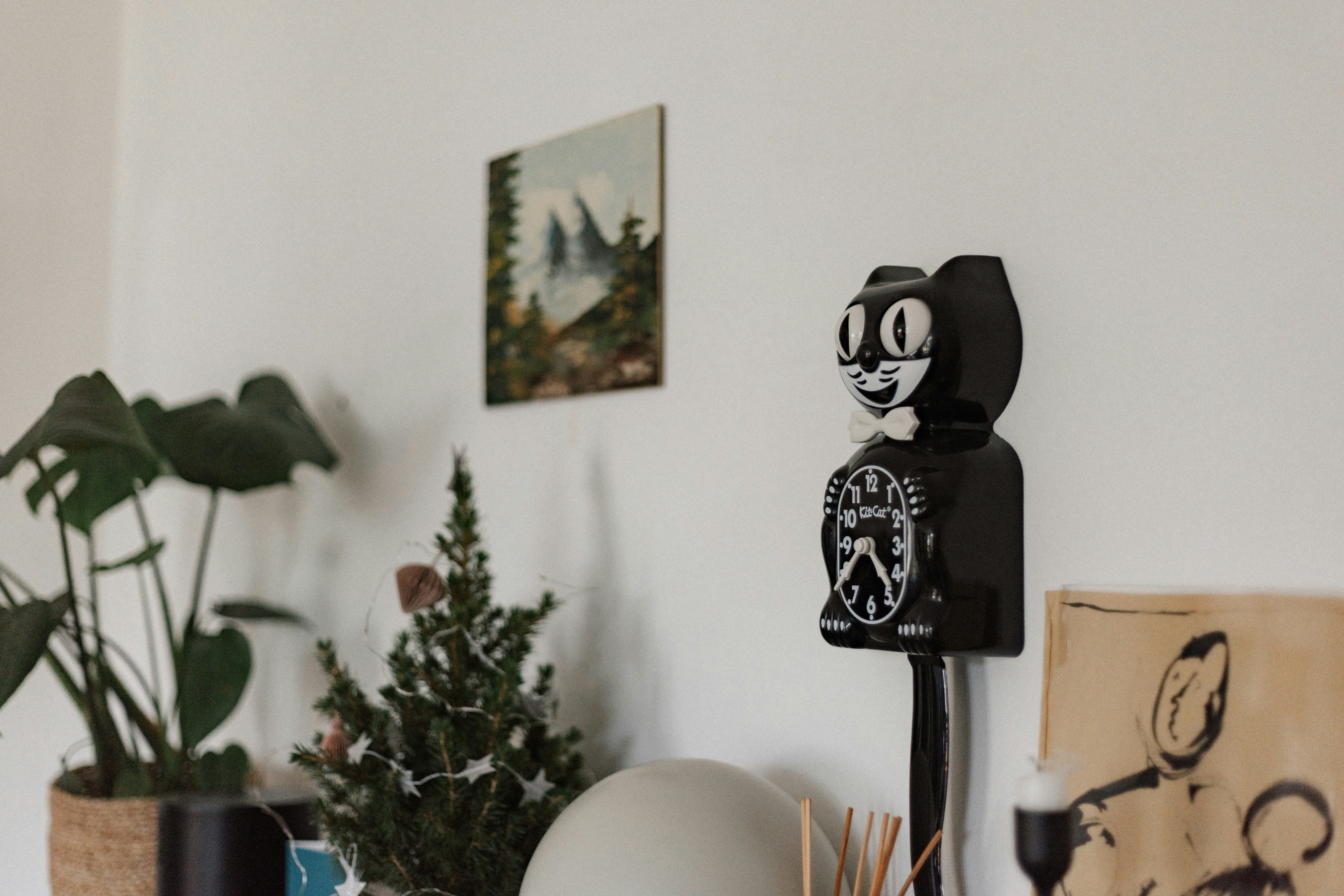 A living room with a lot of plants and pictures on the wall