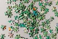 A pile of green and white puzzle pieces