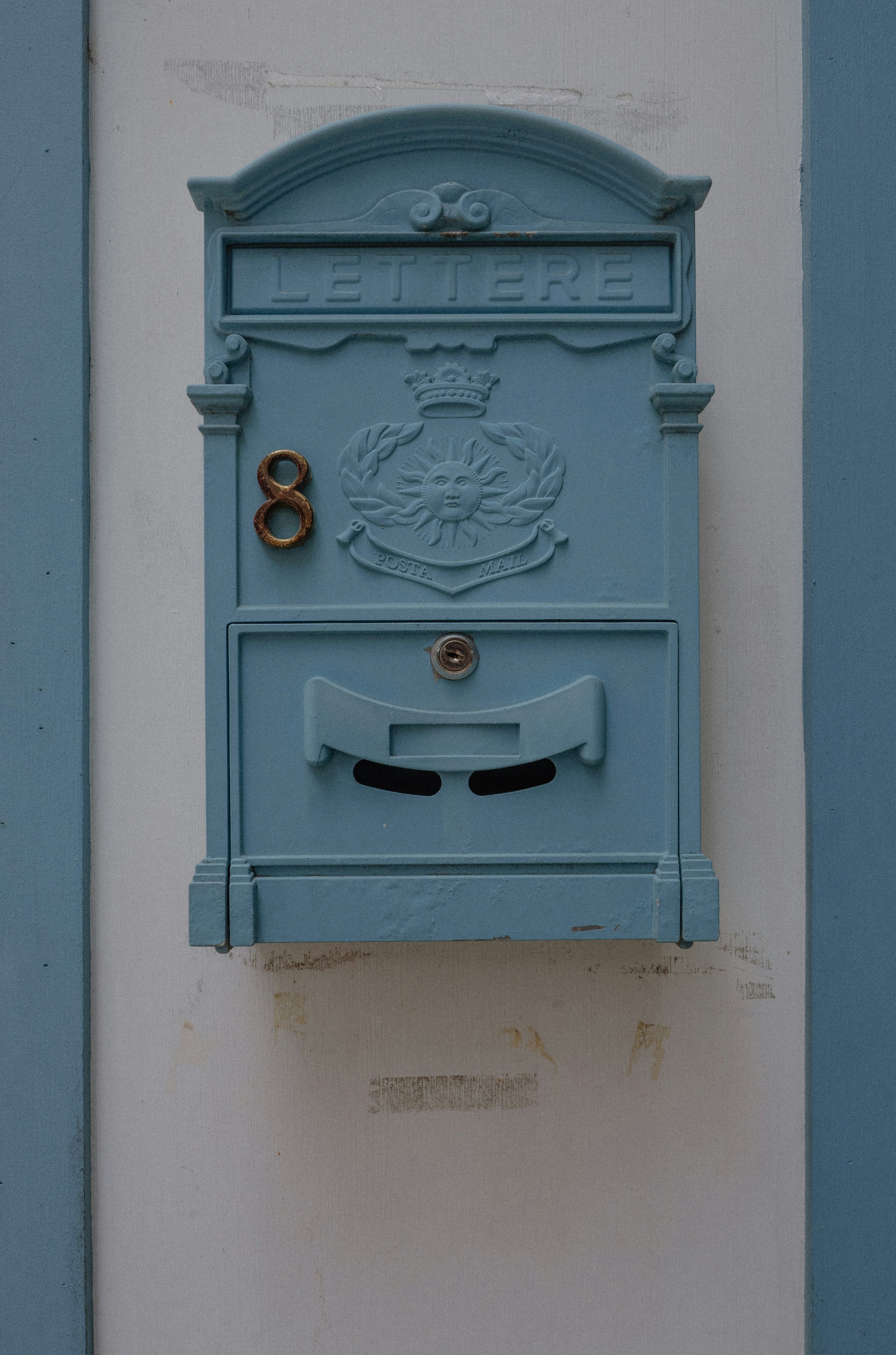 Uma caixa de correio azul montada ao lado de um prédio