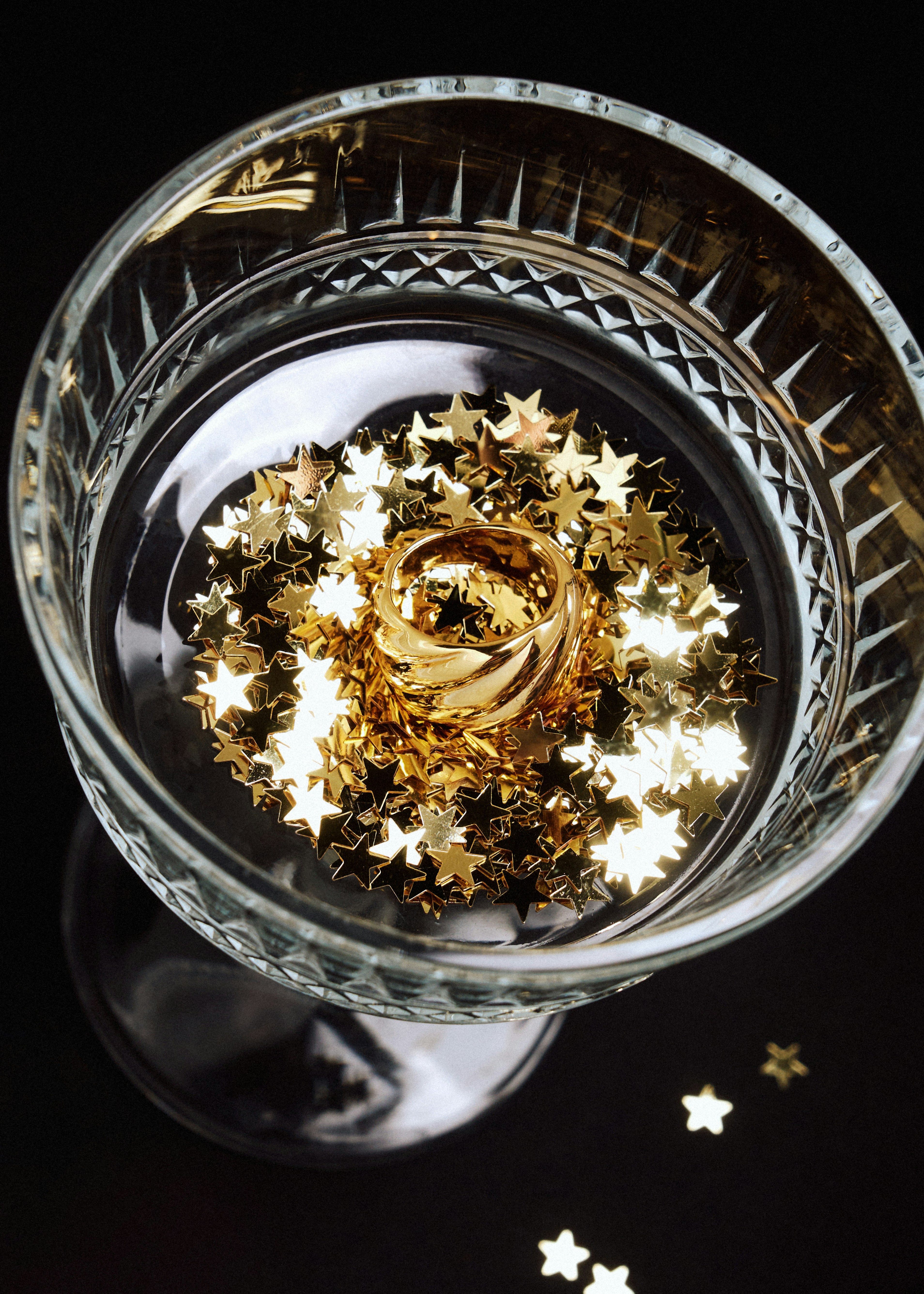 Un cuenco de cristal lleno de estrellas doradas y blancas
